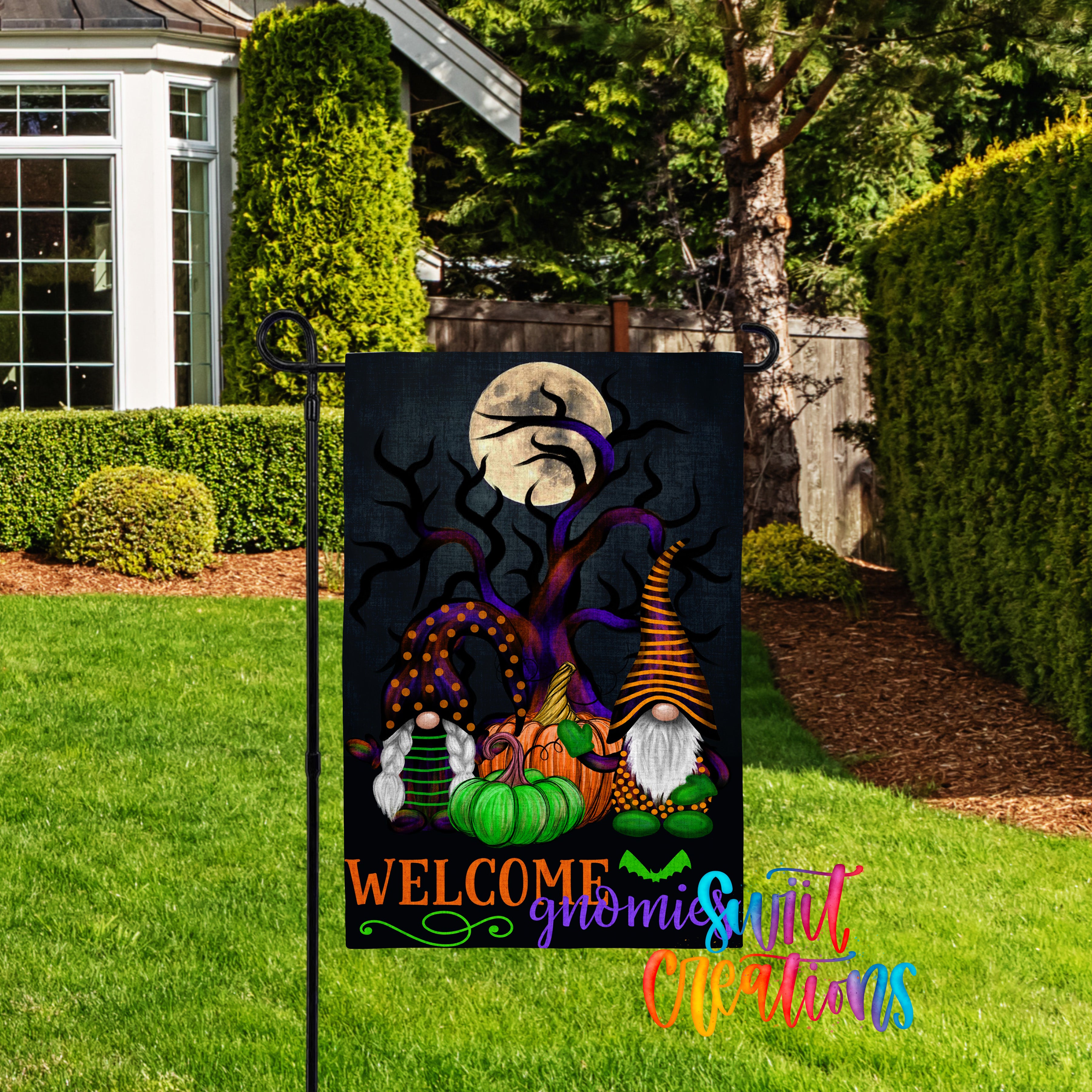 A garden sign featuring a Halloween-themed illustration of gnomes and pumpkins, with a full moon and a spooky tree in the background.