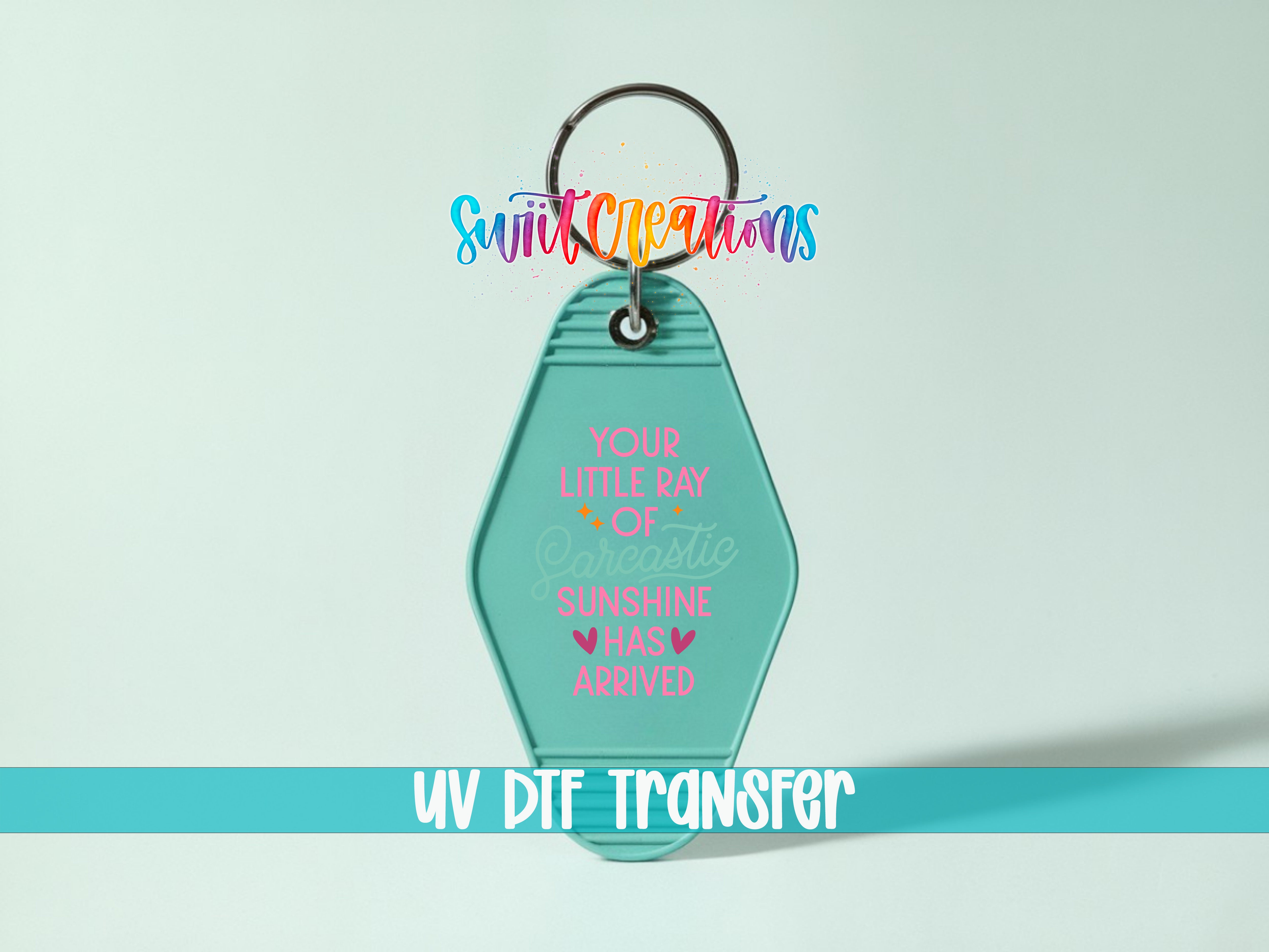 A keychain with a message that says "Your little ray of sunshine has arrived" in a colorful, stylized font.