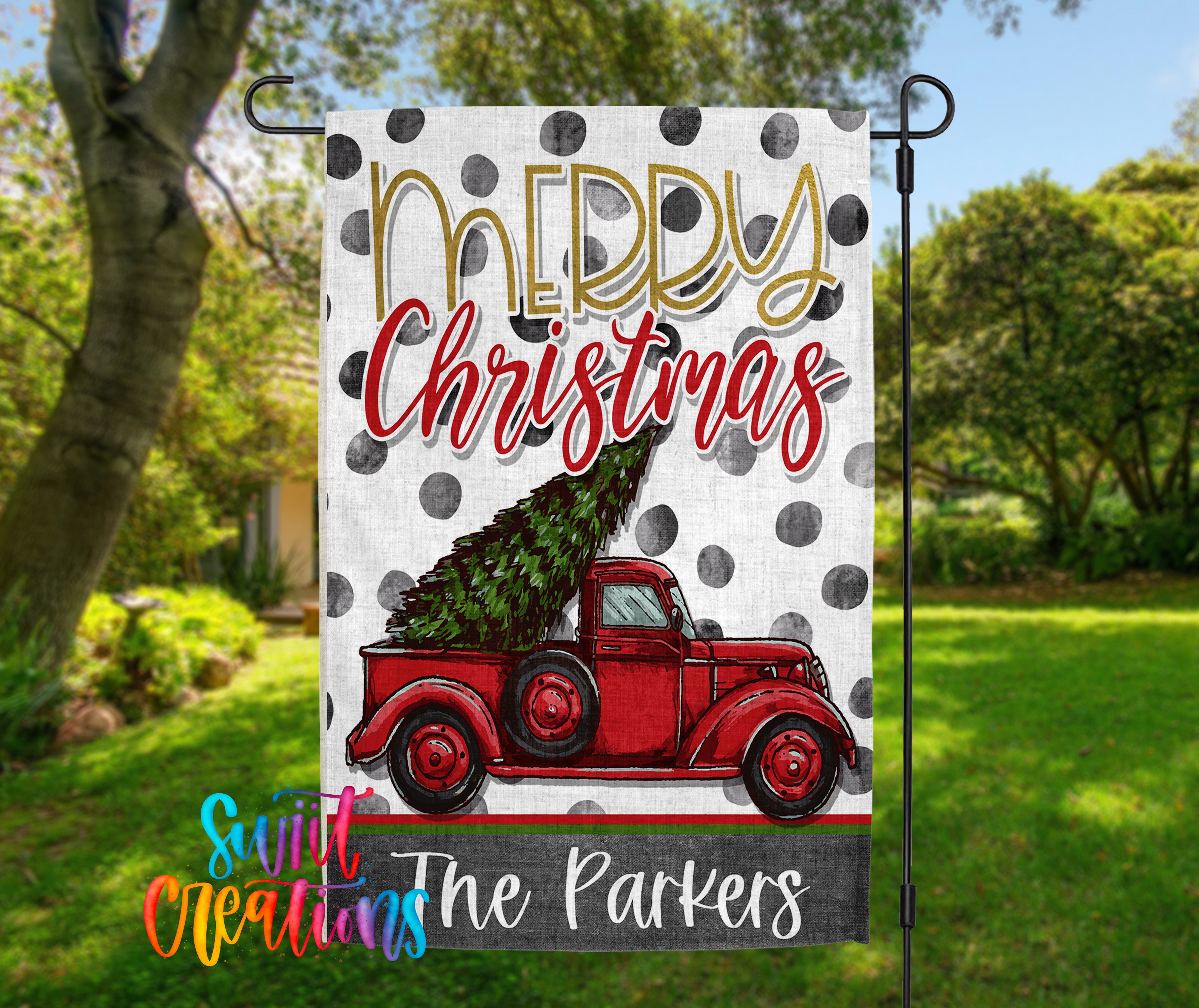 A banner with a red truck carrying a Christmas tree, set against a background of trees and greenery.