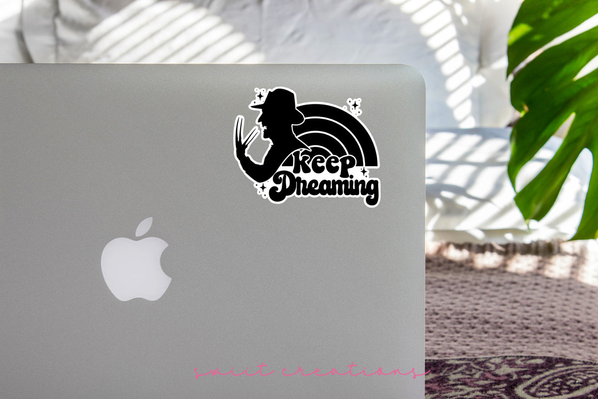 Keep Dreaming sticker on the lid of a silver laptop