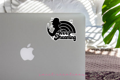 Keep Dreaming sticker on the lid of a silver laptop