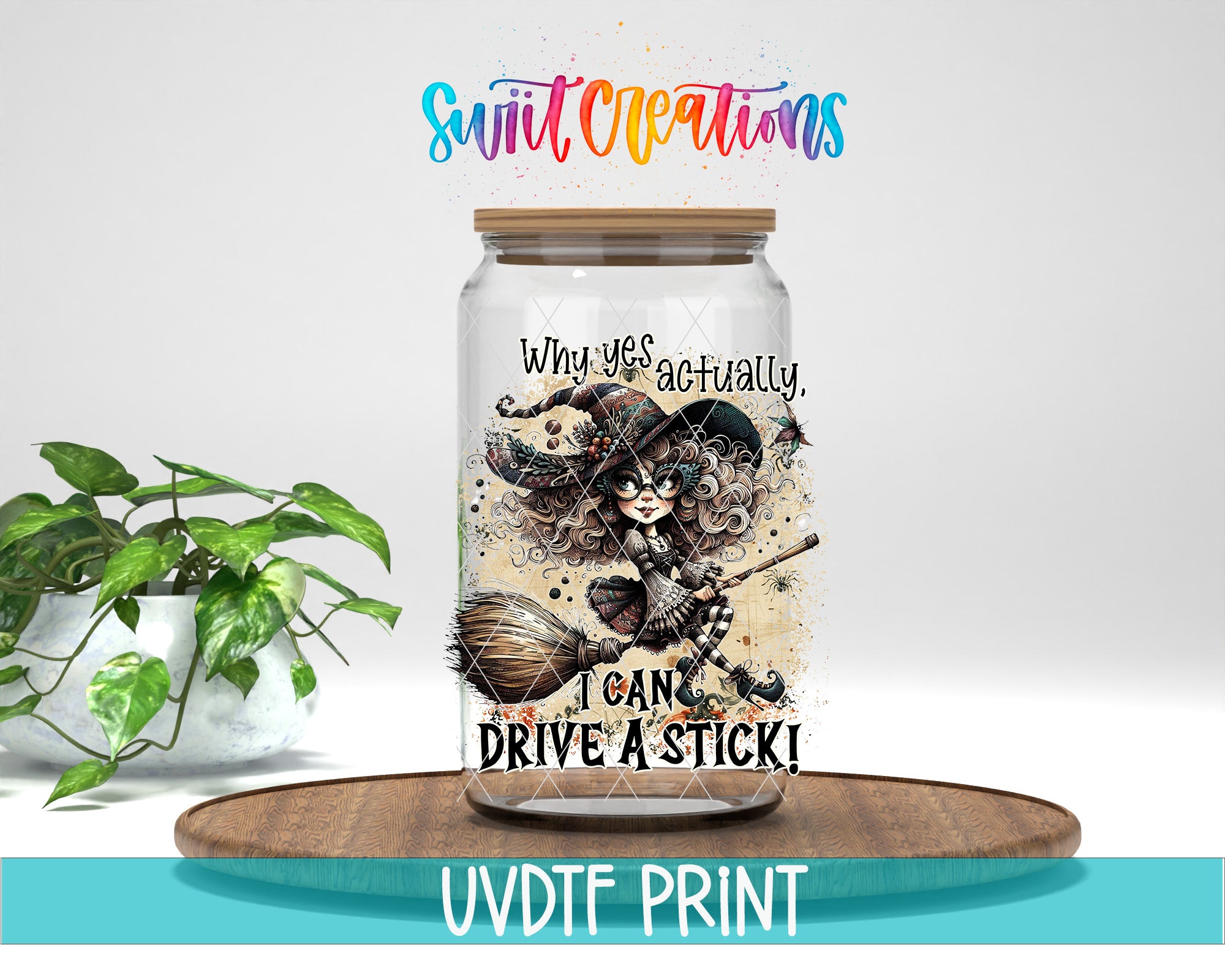 A glass jar with a whimsical illustration of a witch and a broomstick, accompanied by the text "Why yes, actually I can drive a stick!" The jar is placed on a wooden surface, and there is a potted plant in the background.