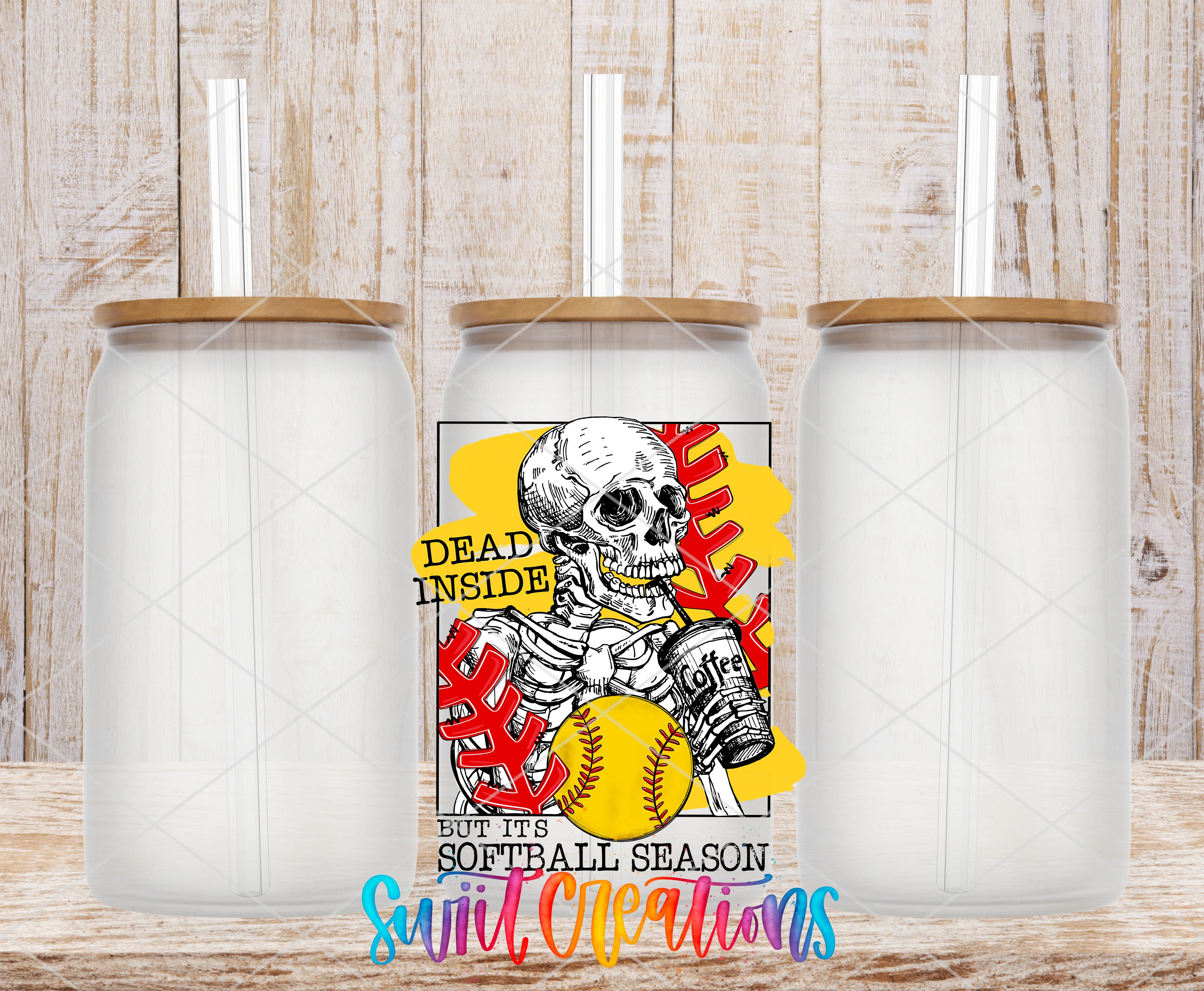 a clear glass tumbler with a printed design on it, including a skull holding a softball and the text "Dead inside but it's softball season".