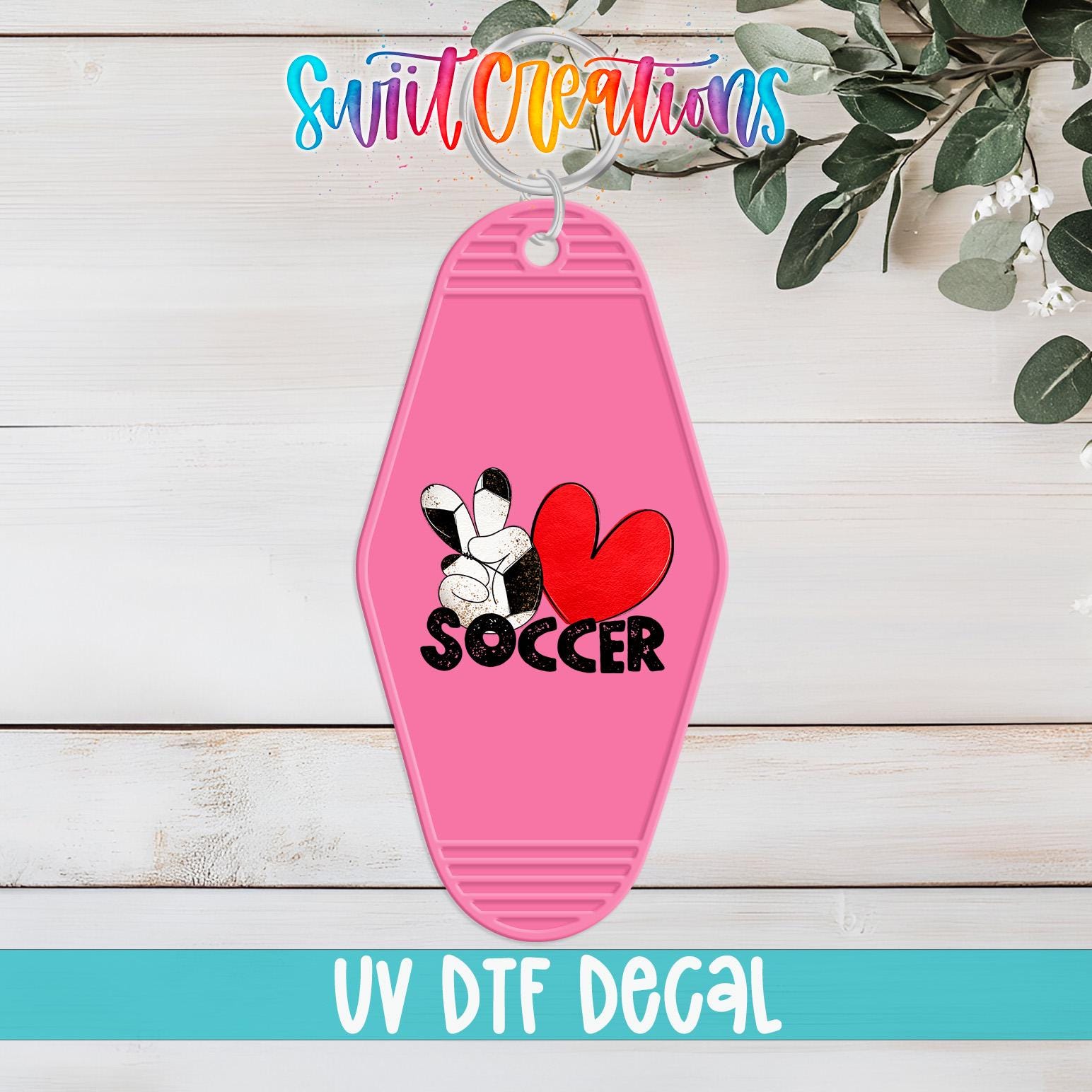A pink keychain with a soccer-themed design, including a heart and the word "SOCCER".