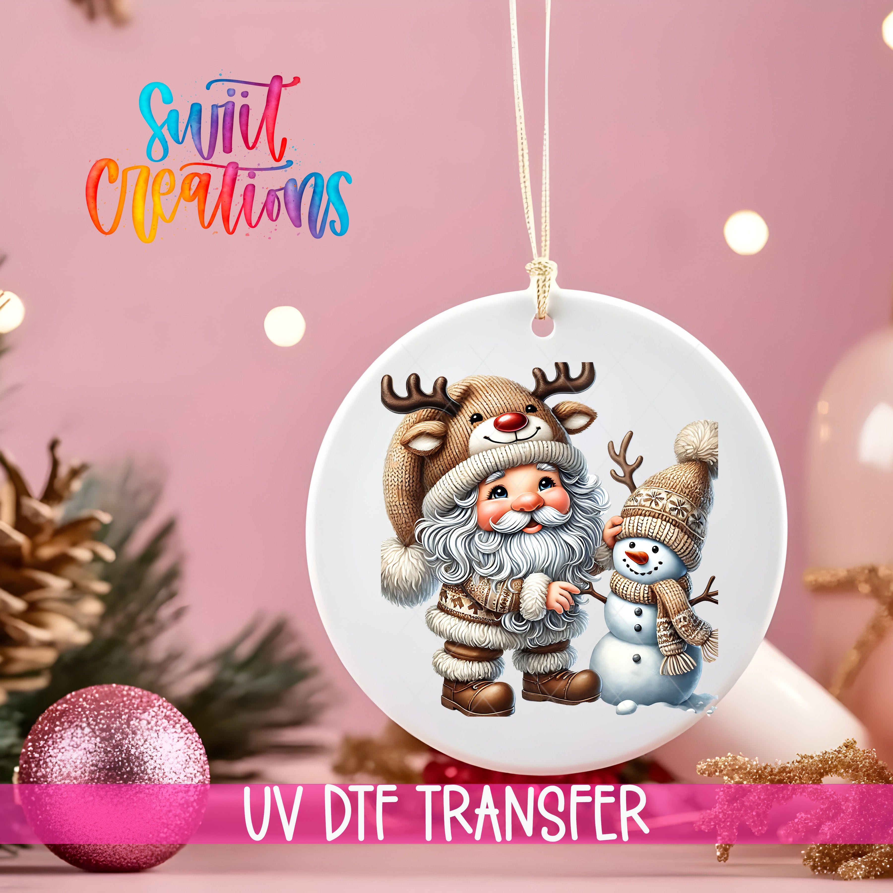 A white ornament with a Santa Claus and a snowman design, hanging on a string against a pink background with Christmas decorations in the background.