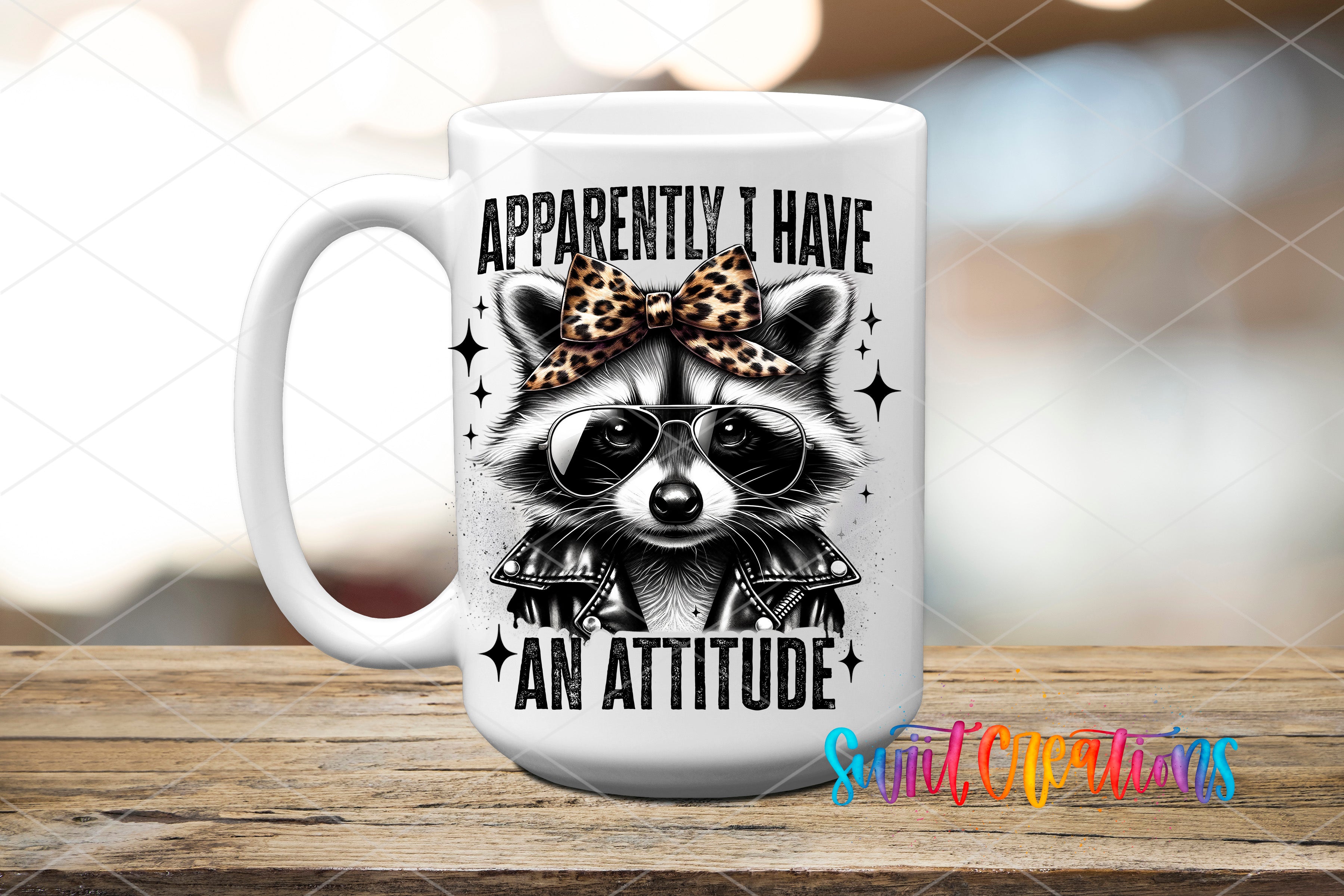 A white ceramic mug with a raccoon wearing sunglasses and a leopard print bow tie, along with the text "Approximately I have an attitude" printed on it.