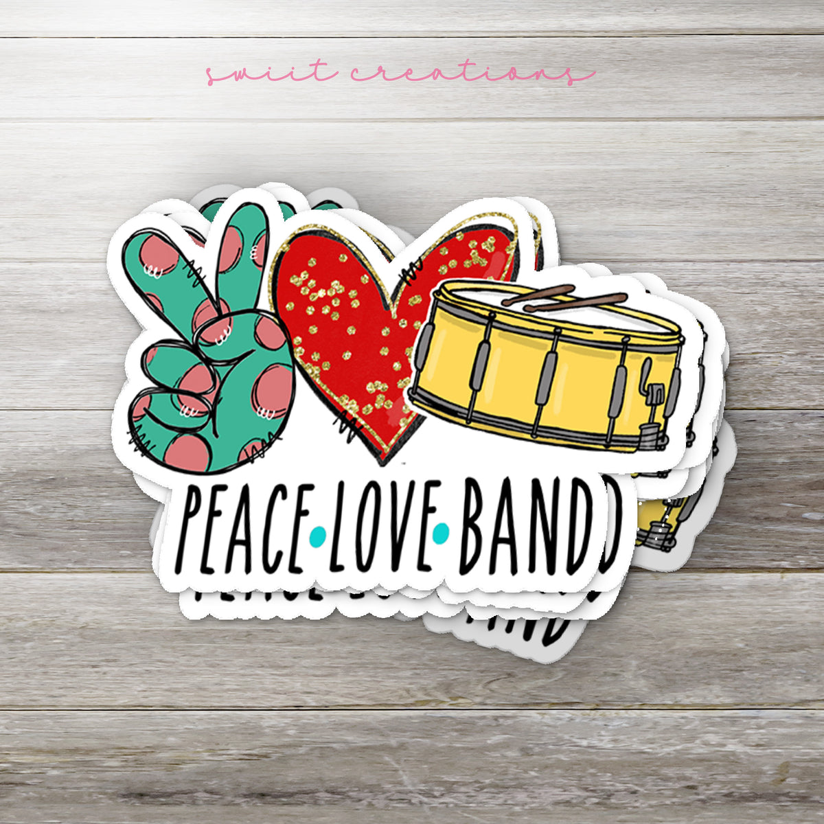 Stack of Peace Love Band glossy stickers on a gray wood table