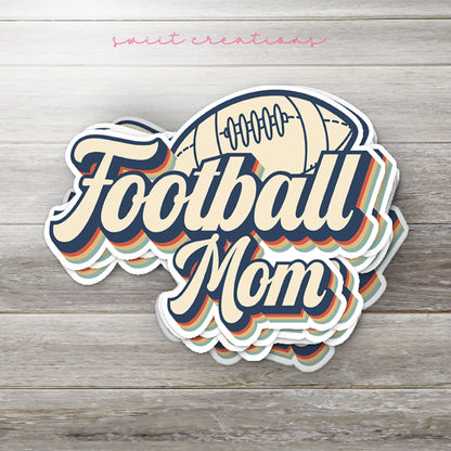 Stack of Football Mom glossy stickers on a gray wood table