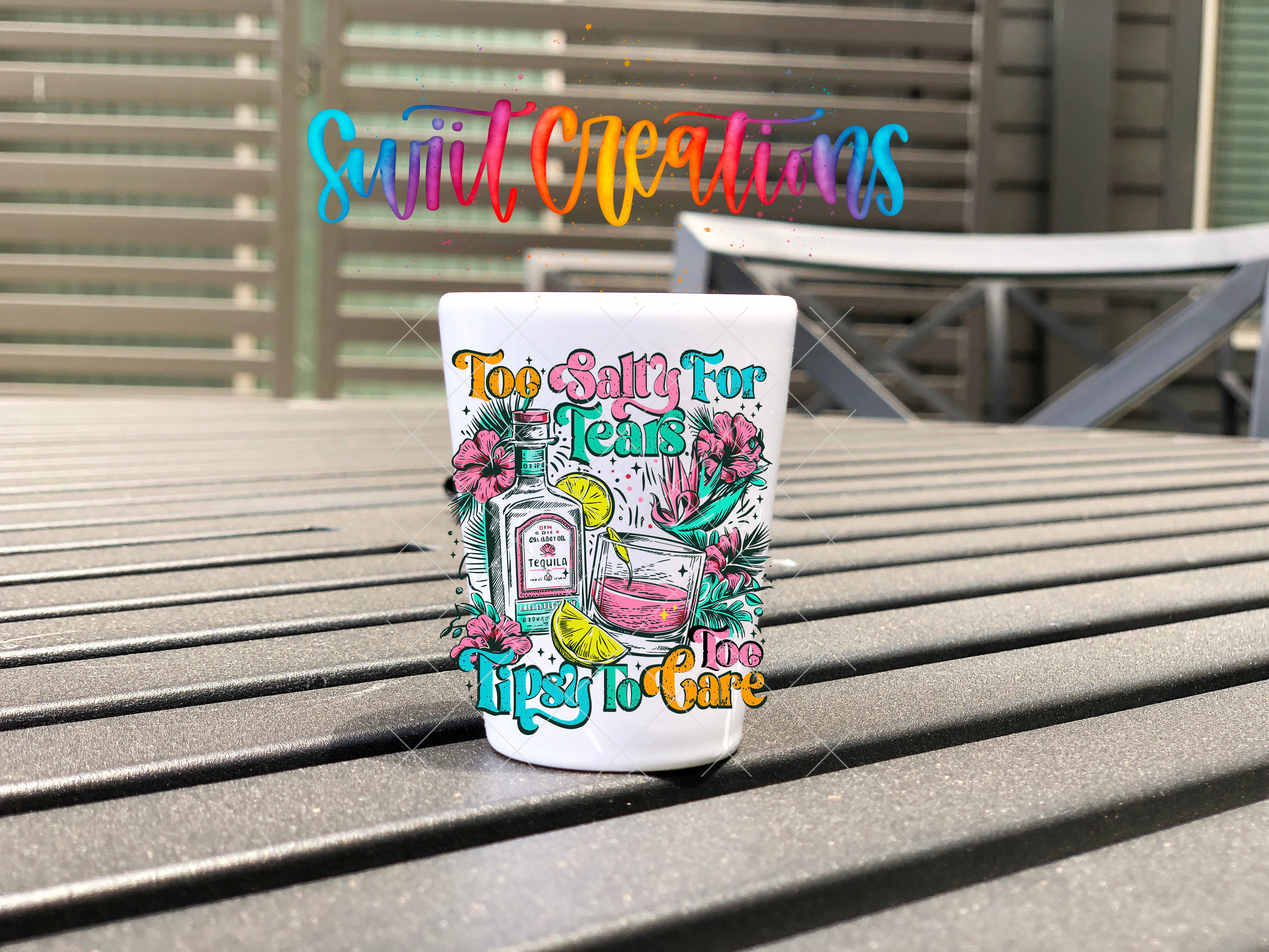 A colorful mug with a whimsical design sits on a wooden surface, with a colorful text overlay that reads "Swift Creations" and "Too Salty for Teas".
