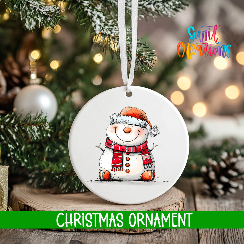 A white Christmas ornament featuring a smiling snowman is hanging from a tree branch, with a blurred background of pine branches and twinkling lights.