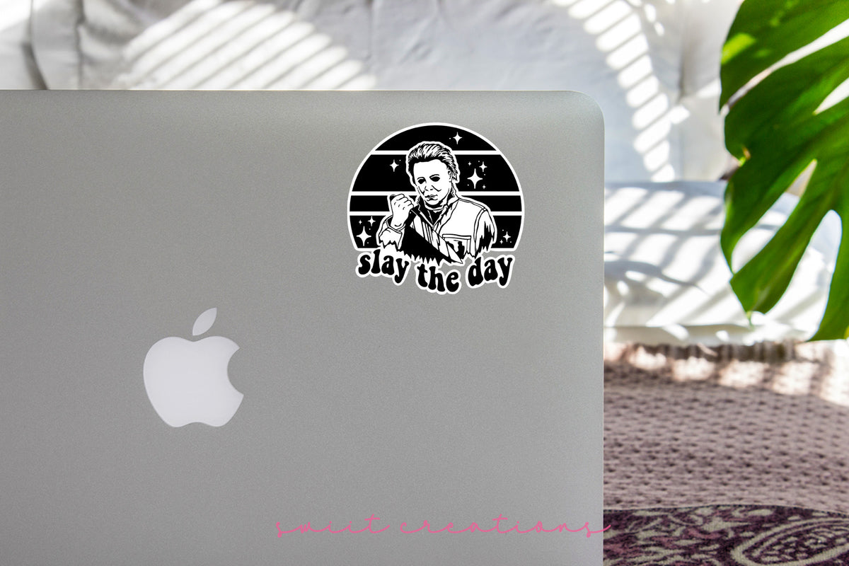 Slay the Day sticker on the lid of a silver laptop