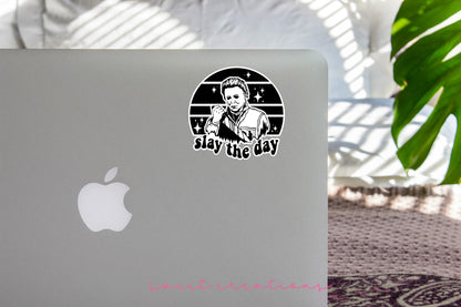 Slay the Day sticker on the lid of a silver laptop