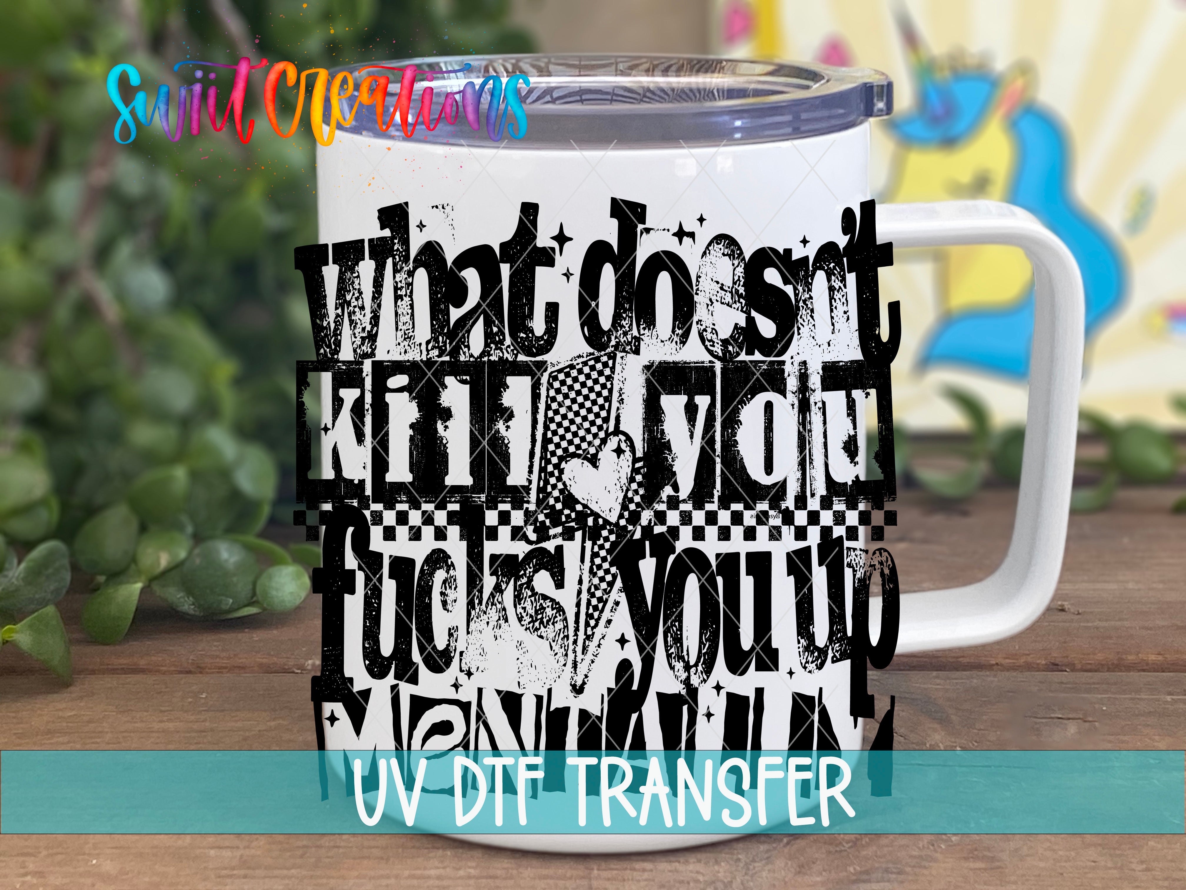 A white mug with a black and white text design printed on it, sitting on a wooden surface.