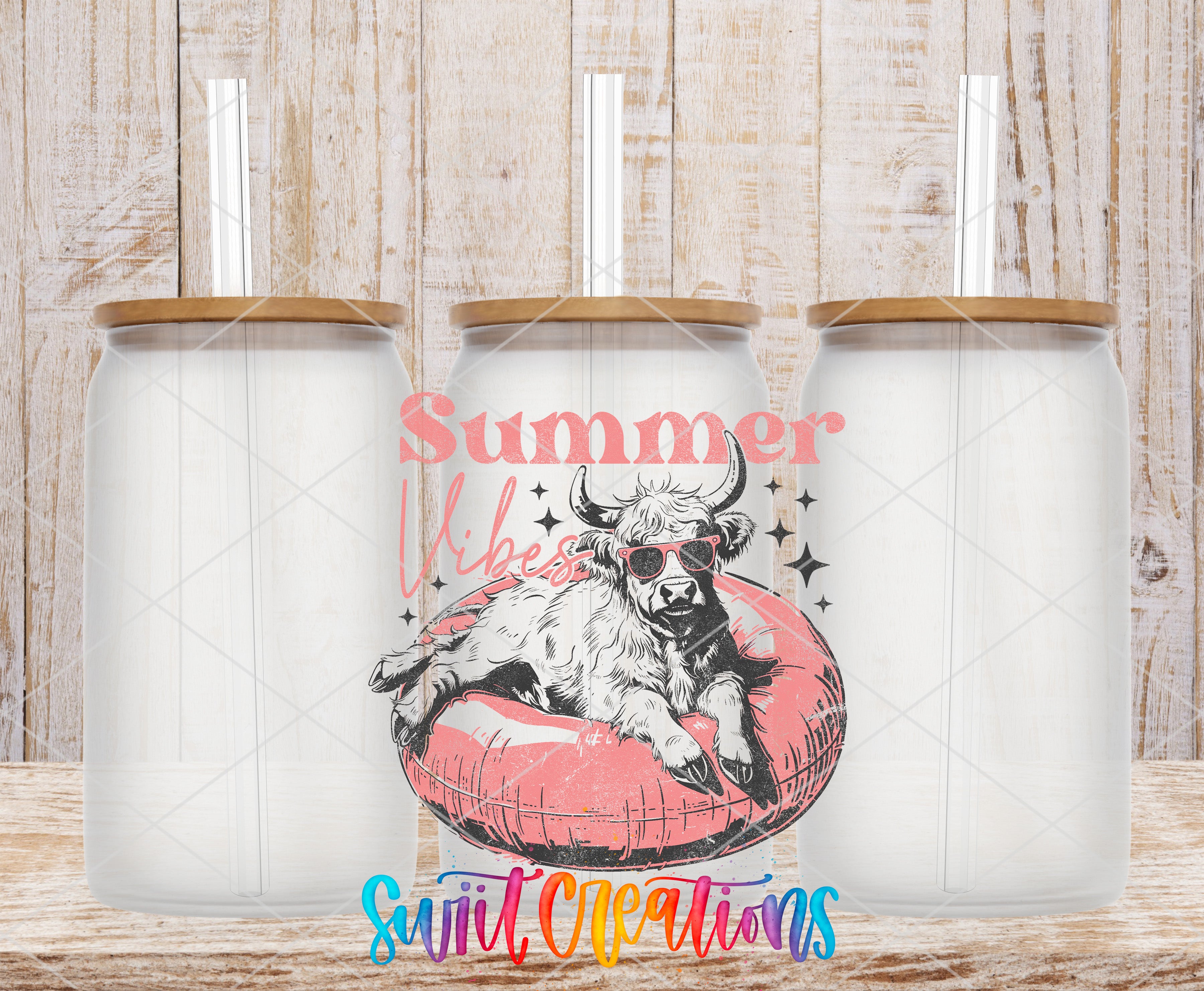 three clear glass tumblers with straws, each with a lid and a straw, arranged in a row. The tumblers have a design of a cow wearing sunglasses and resting on a red inner tube. The background is a wooden wall with a distressed texture.