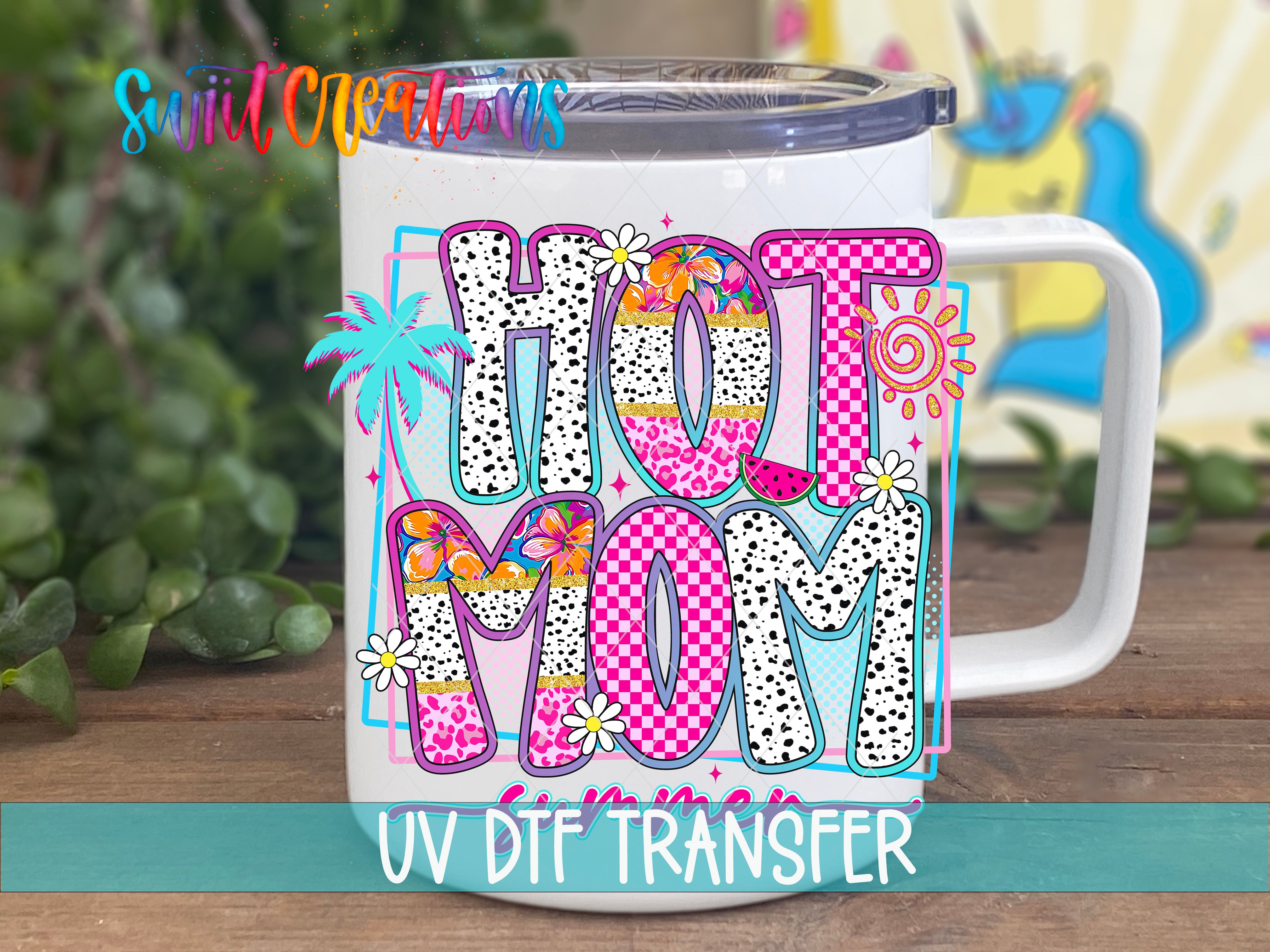 A white mug with colorful text and designs, including the word "Hot Mom" and various floral and geometric patterns.