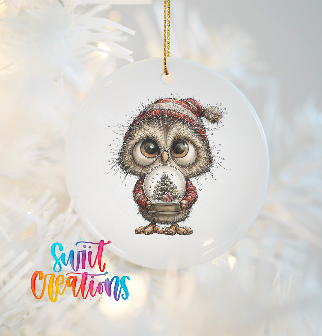 A white ornament featuring a cartoon owl wearing a Santa hat and holding a snow globe with a Christmas tree inside.