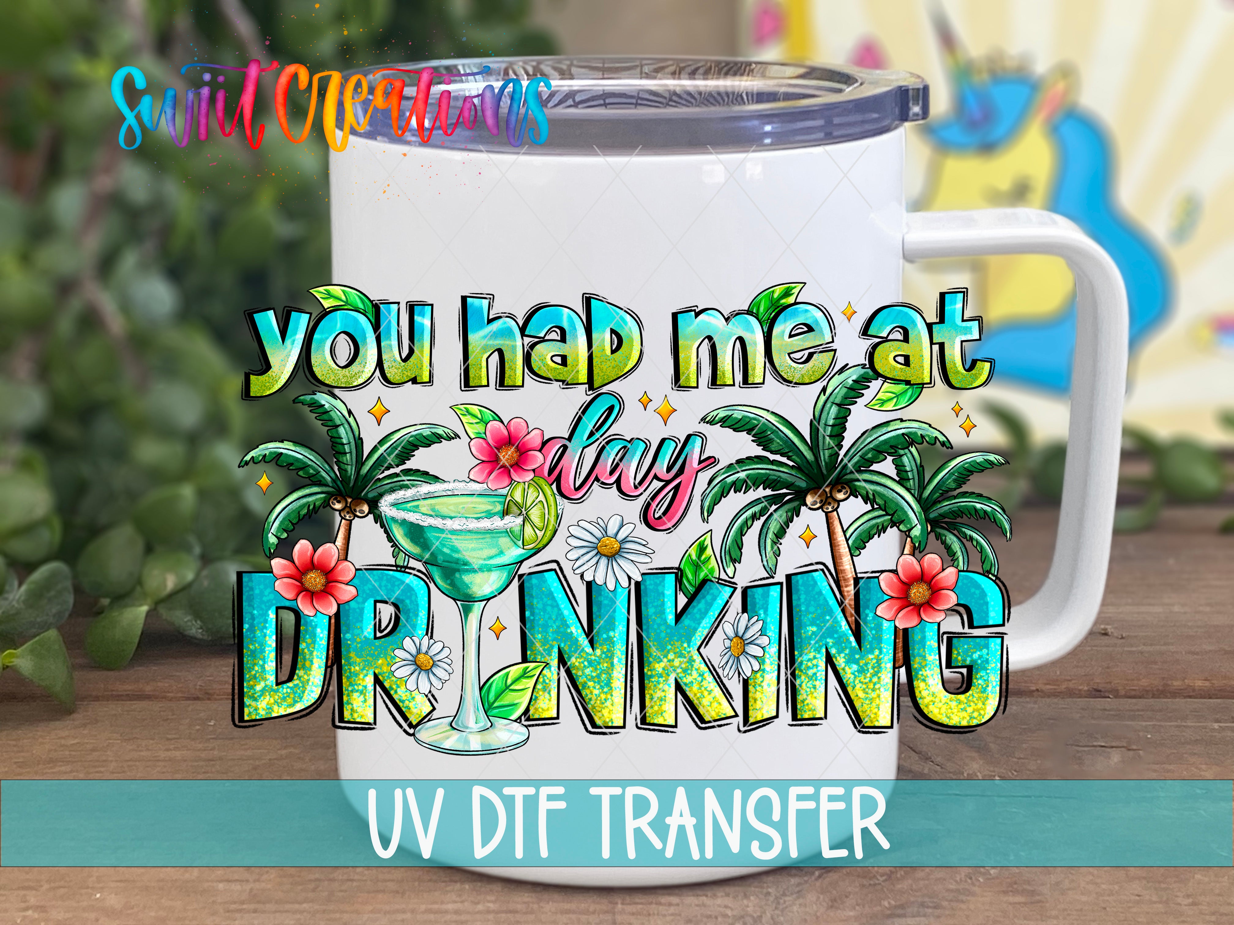 A white mug with a colorful graphic design featuring a tequila glass, palm trees, and flowers, along with the text "you had me at DRINKING".