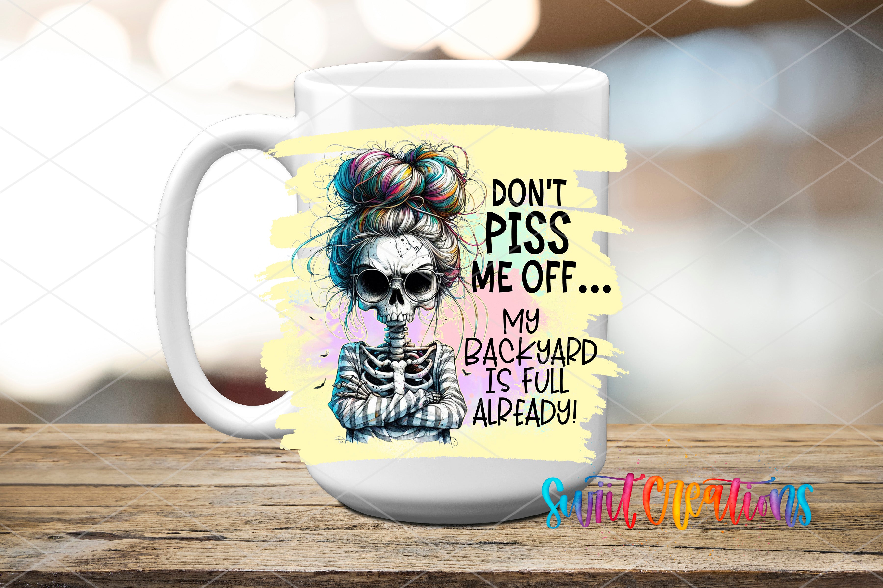 A white mug with a skull design and text on it, placed on a wooden surface.