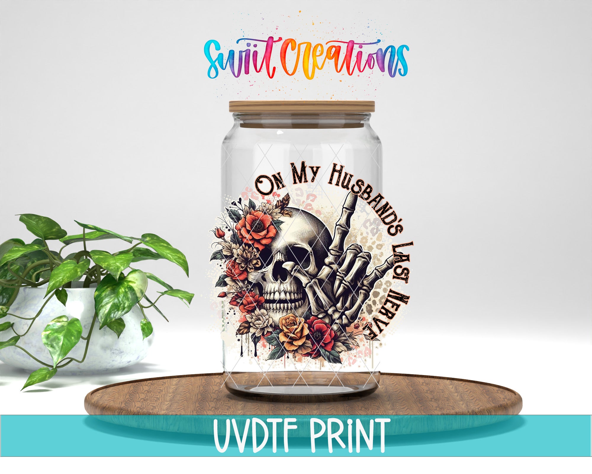A glass jar with a skeleton hand and floral design, placed on a wooden surface.