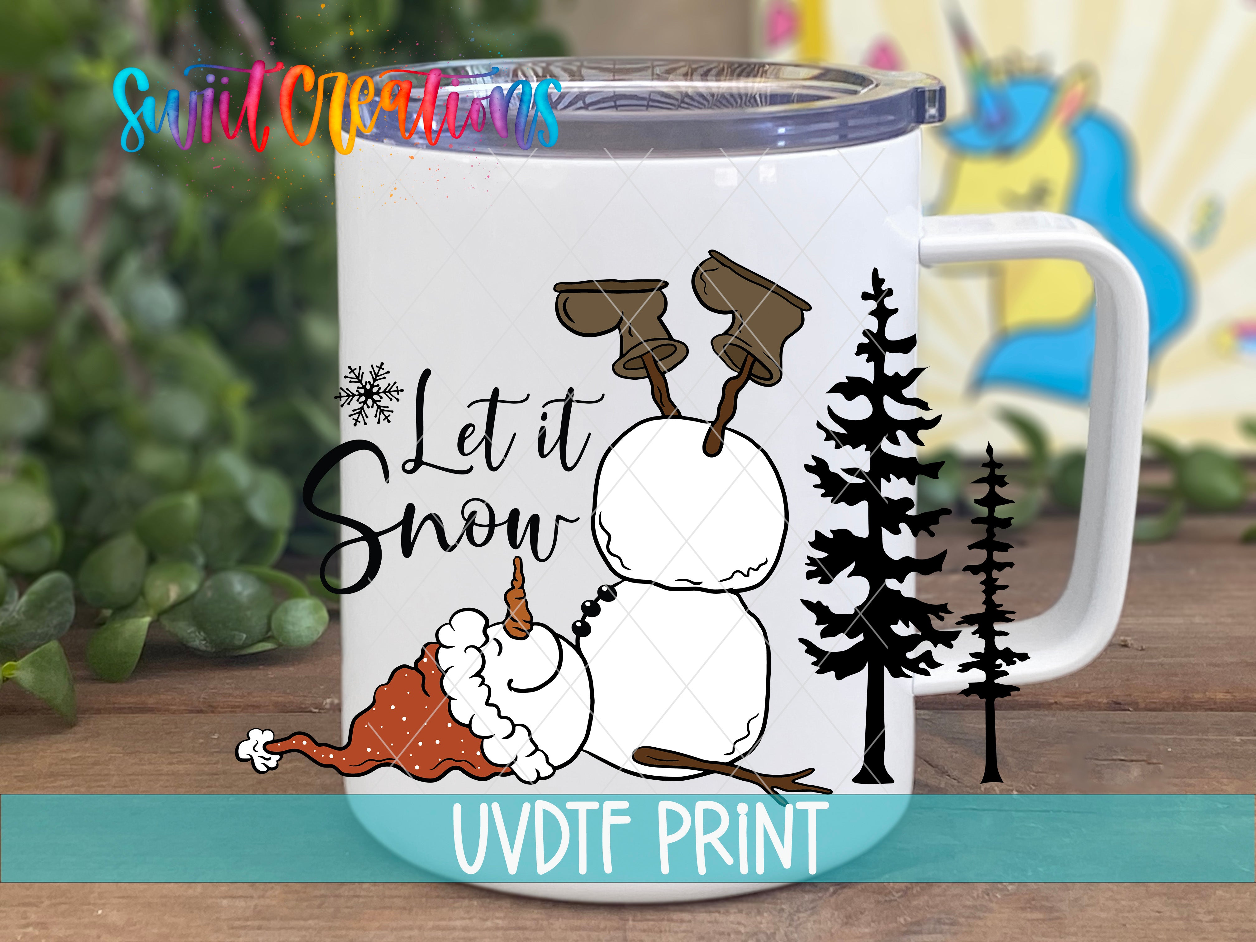 A white mug with a snowman and pine trees design, along with the text "Let it Snow" and a snowflake.