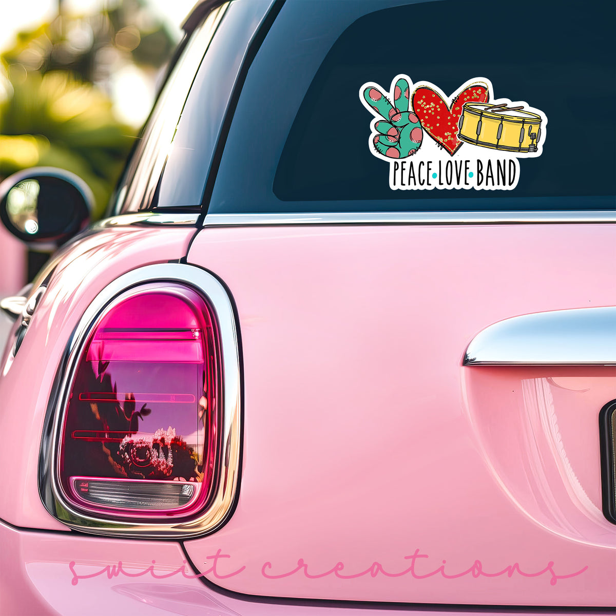 Peace Love Band sticker on the back window of a pink car
