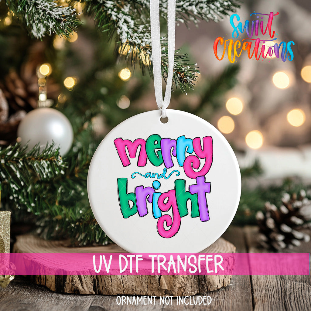 A white ornament with the text "Merry and Bright" in colorful letters hangs from a Christmas tree.