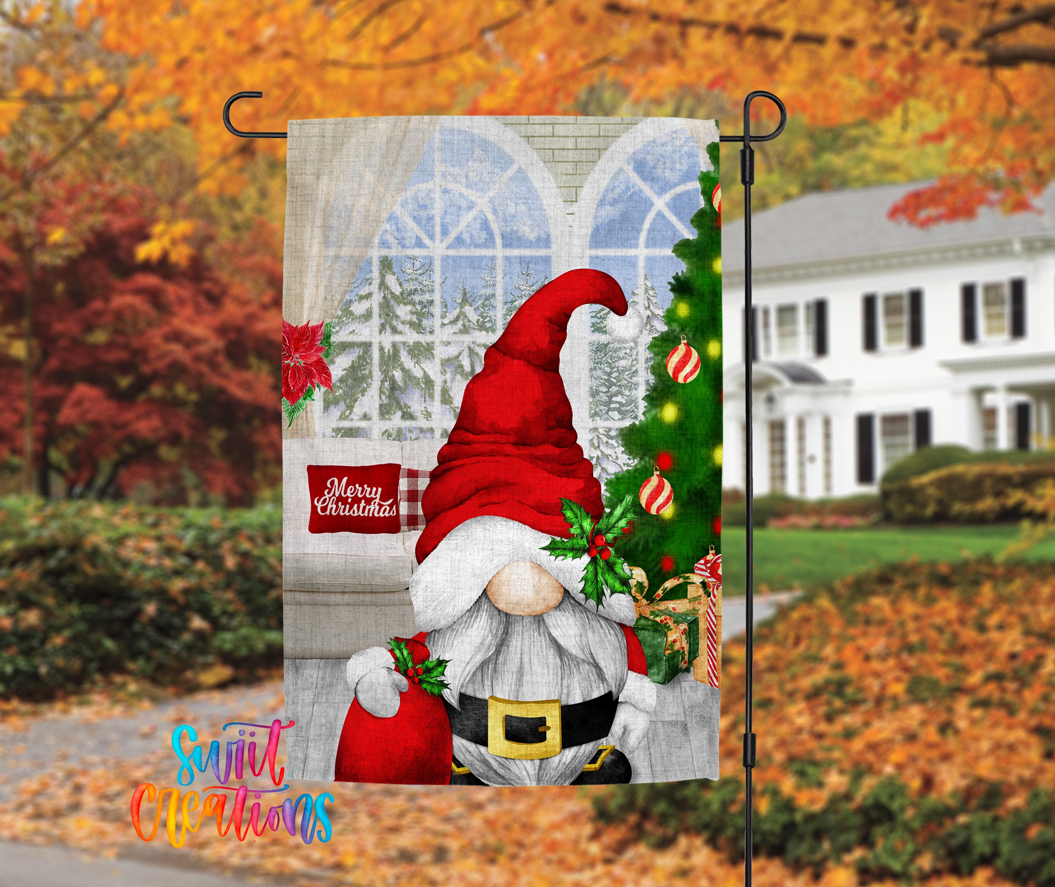 A Christmas-themed garden flag featuring a gnome wearing a Santa hat and holding a sack of presents, with a snowy landscape and a Christmas tree in the background.