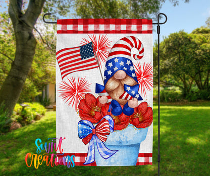 A patriotic flag featuring a gnome holding an American flag and red and white flowers, with a red and white checkered border and a blue and white bow.