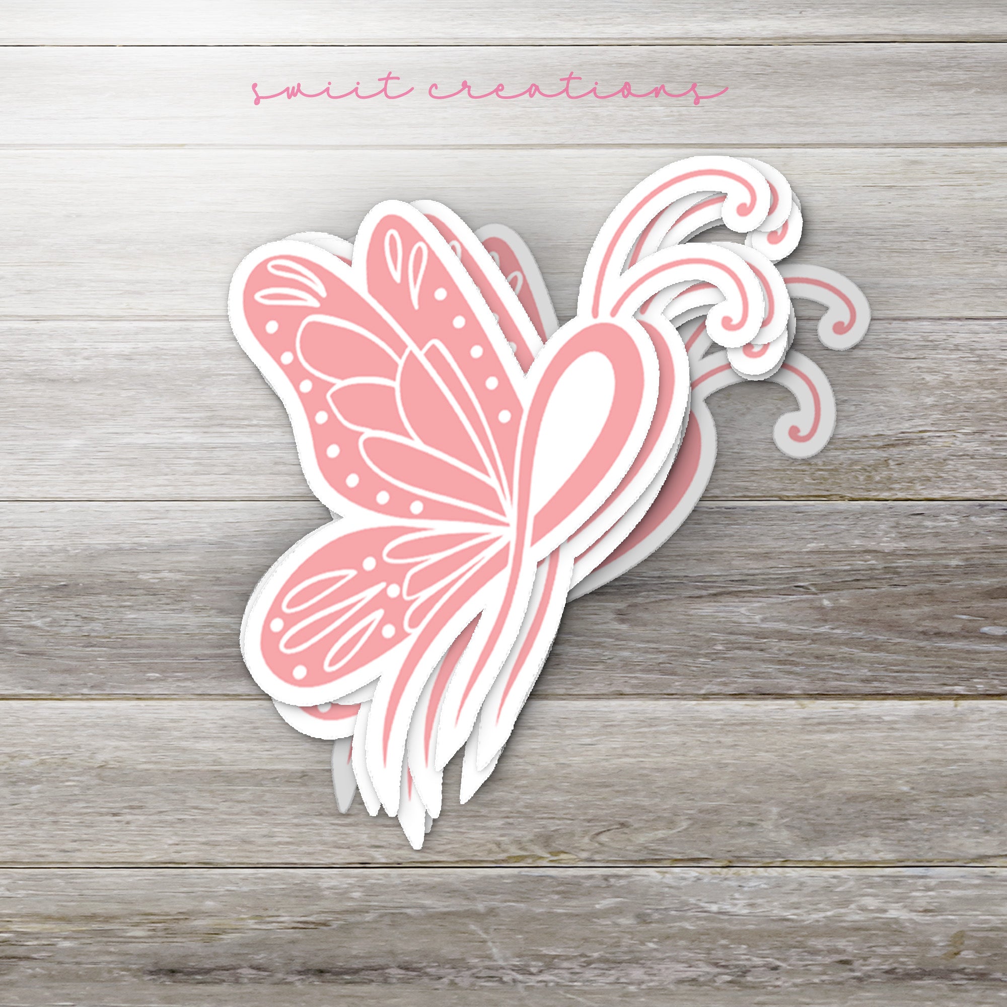 a pink butterfly sticker sitting on top of a wooden table