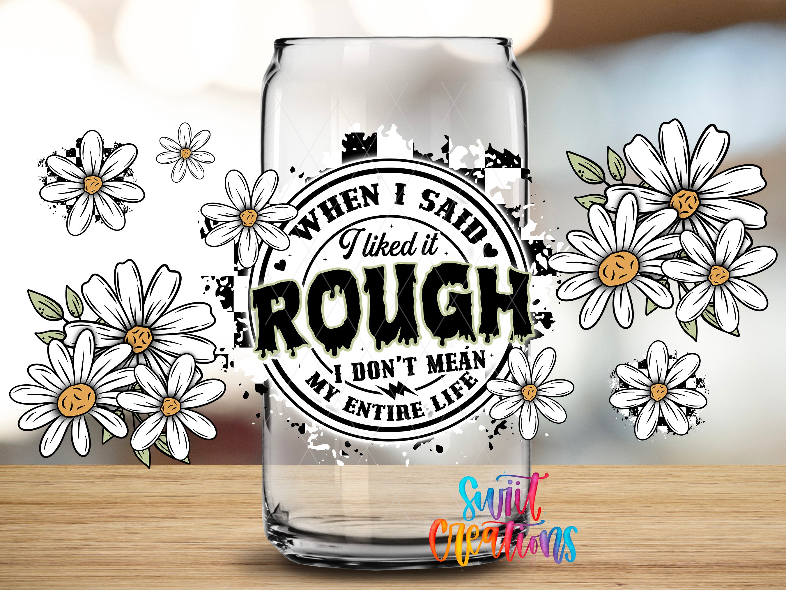 a glass with a sticker on it, surrounded by white flowers.