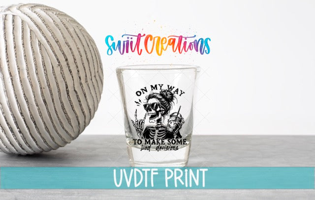 a ball of yarn next to a shot glass