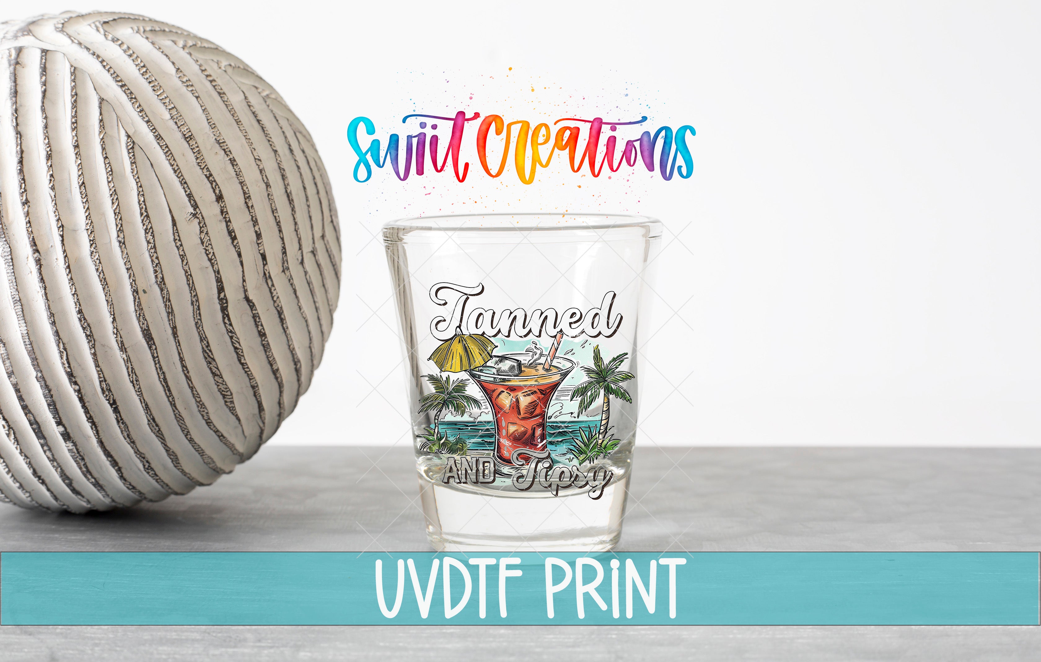 a shot glass next to a ball of yarn