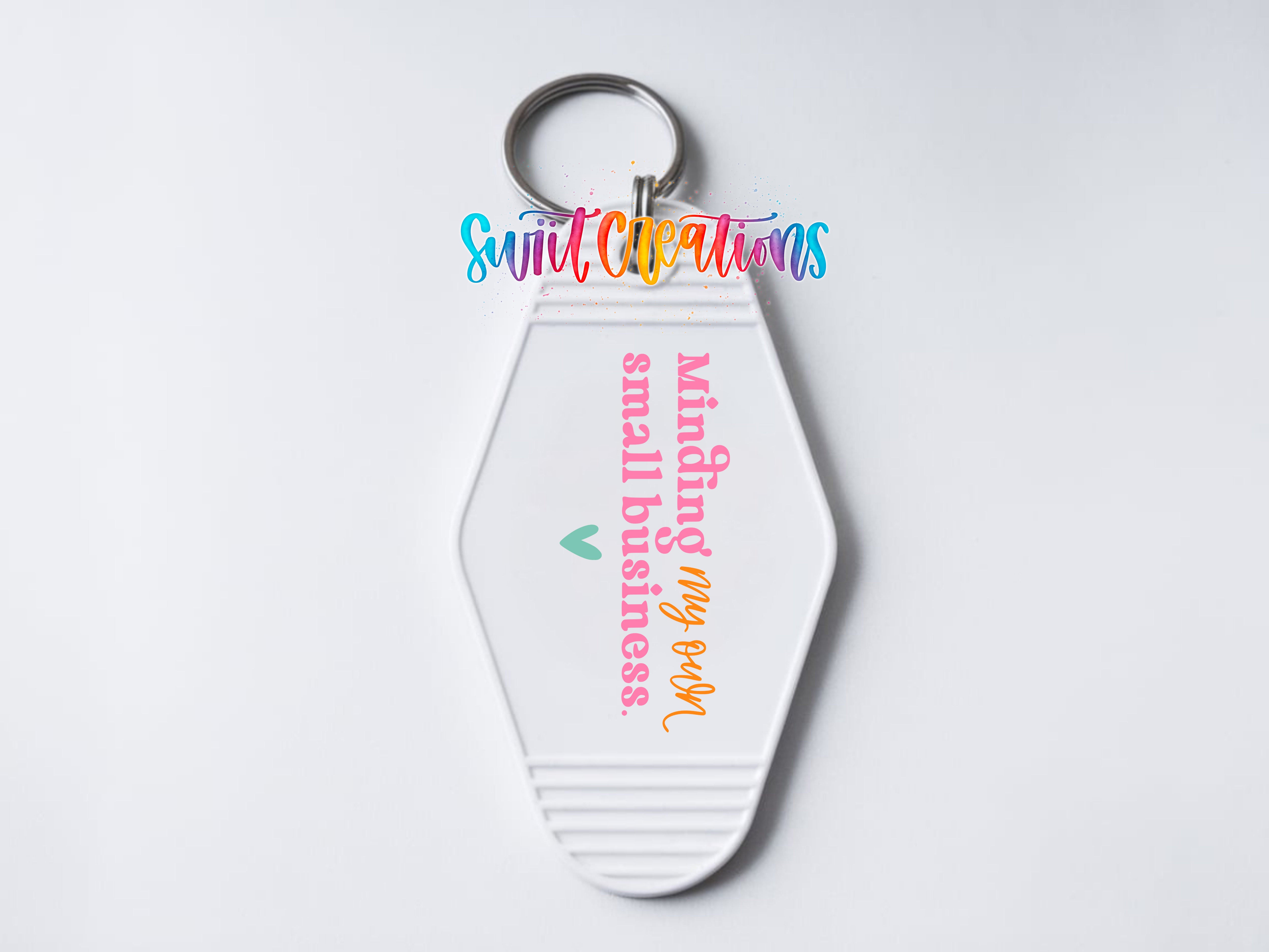 A keychain with a message that says "Minding my own business" in a colorful, cursive font.