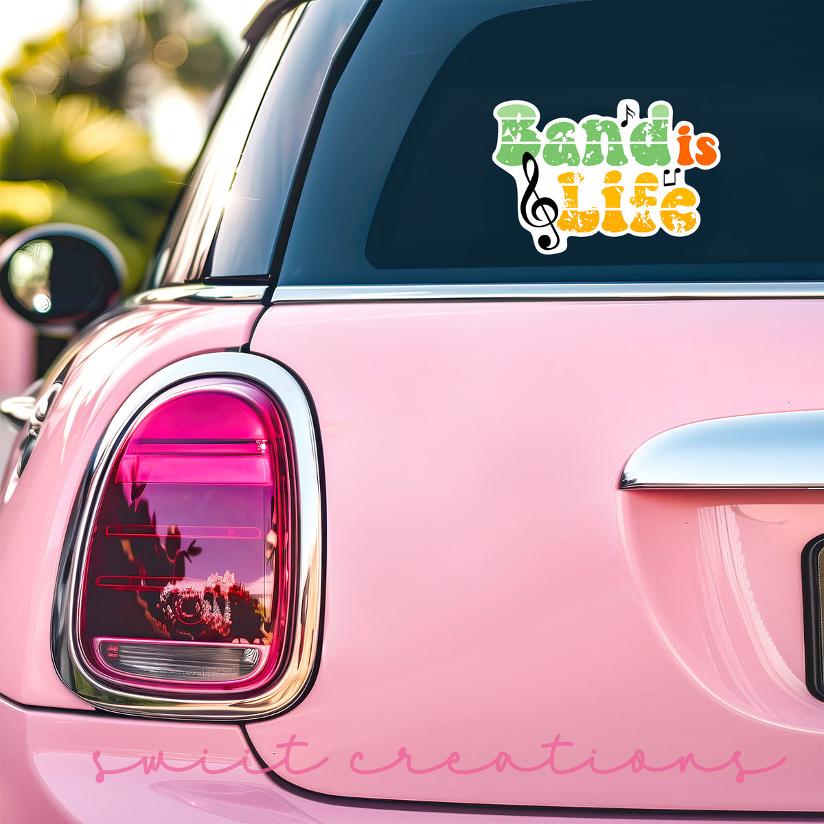 Band Is Life sticker on the back window of a pink car