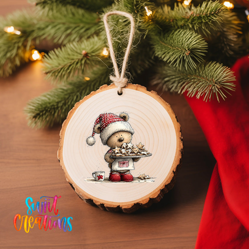 A wooden ornament featuring a teddy bear holding a tray of cookies, hanging on a Christmas tree.