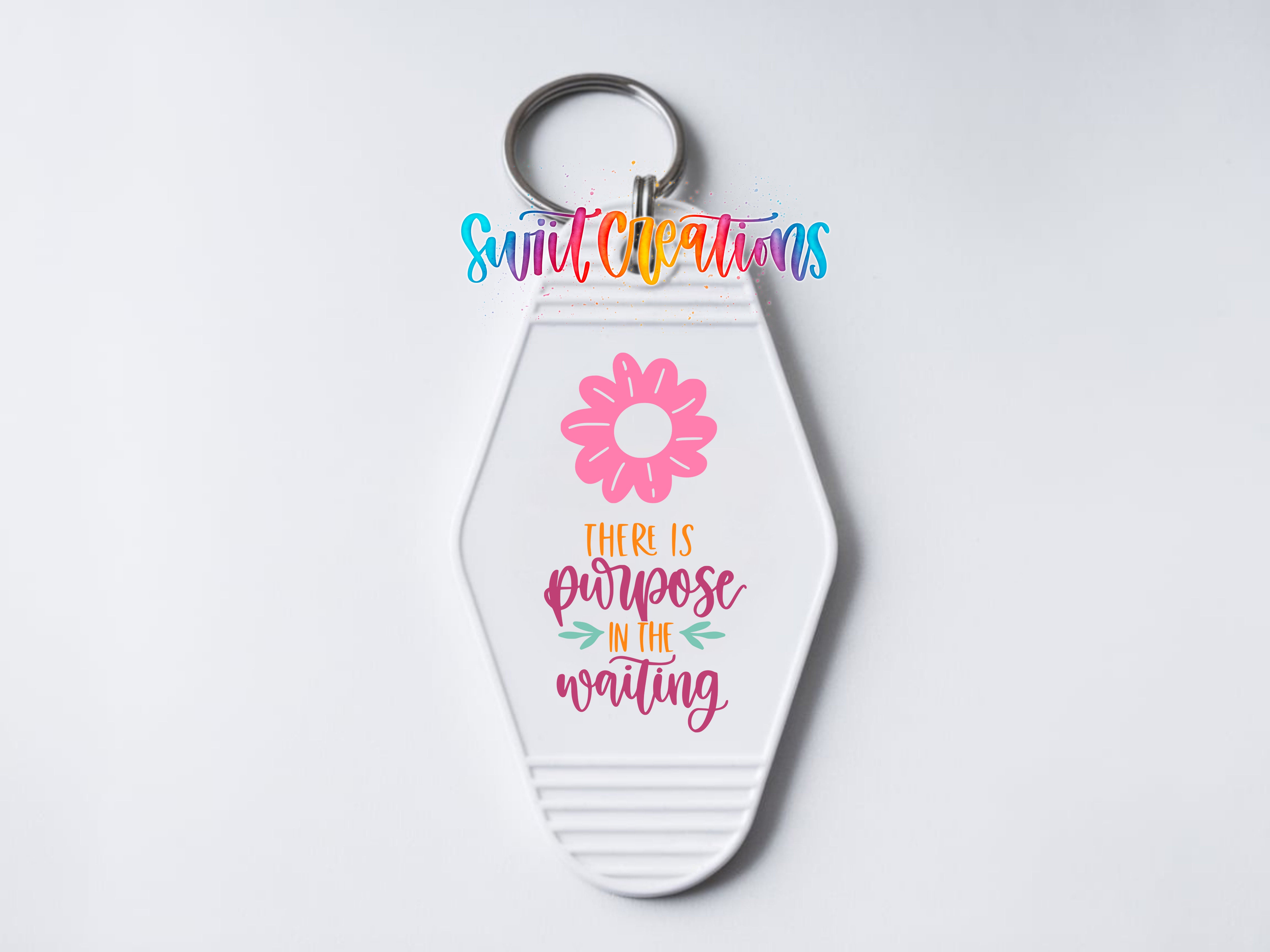A keychain with a flower design and text that reads "There is purpose in the waiting".