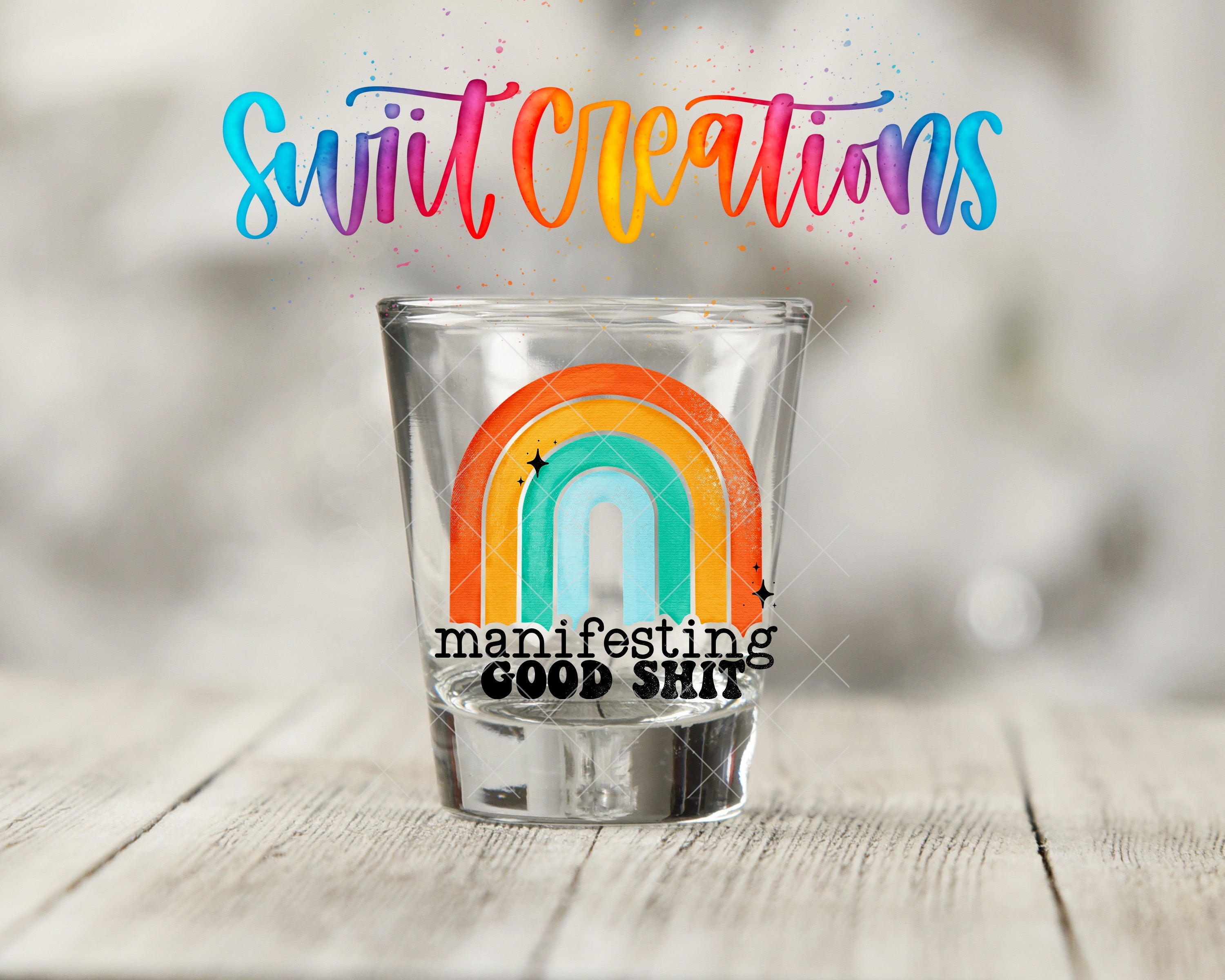 a shot glass with a rainbow painted on it