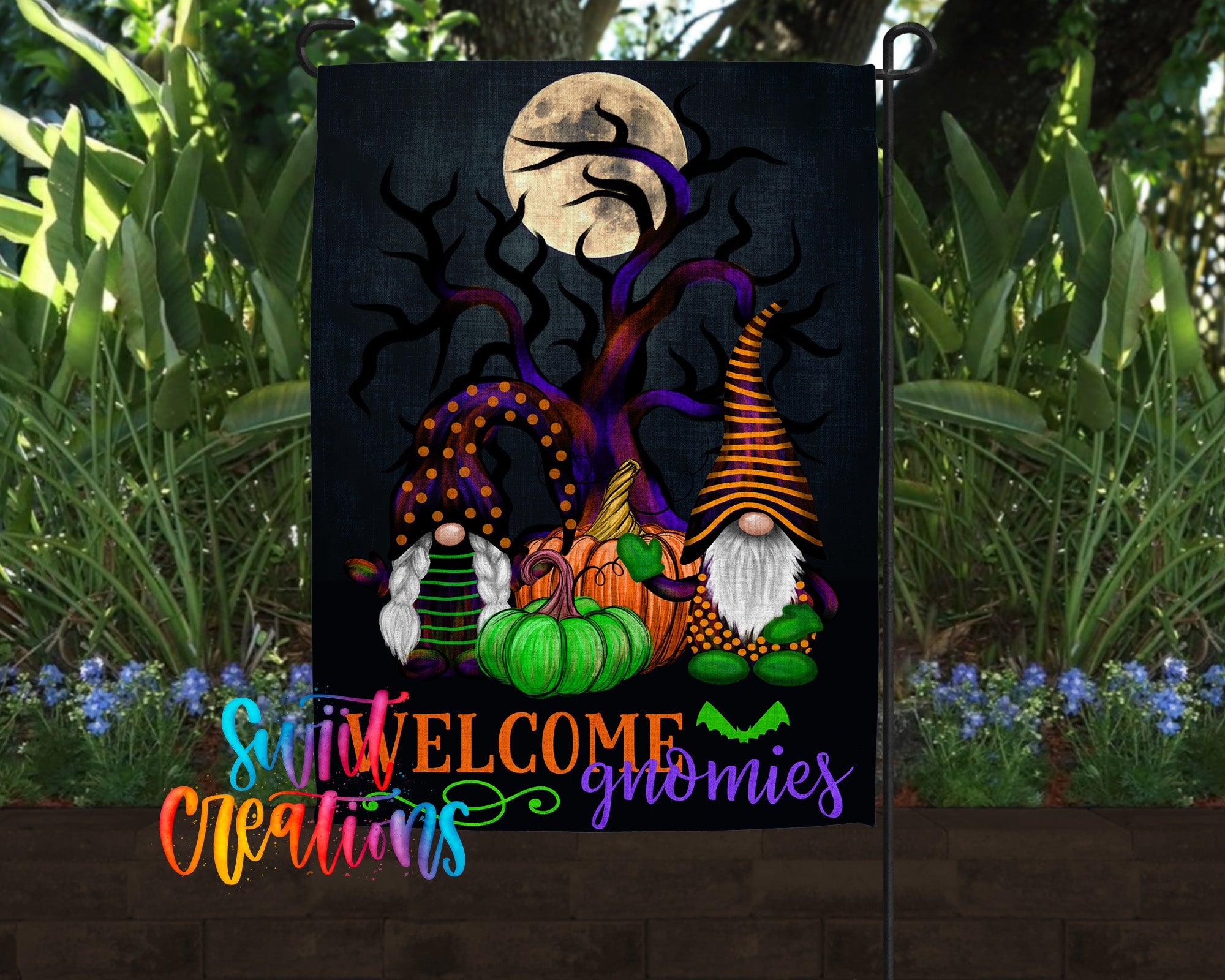 A garden flag featuring a spooky Halloween scene with gnomes, pumpkins, and a full moon.