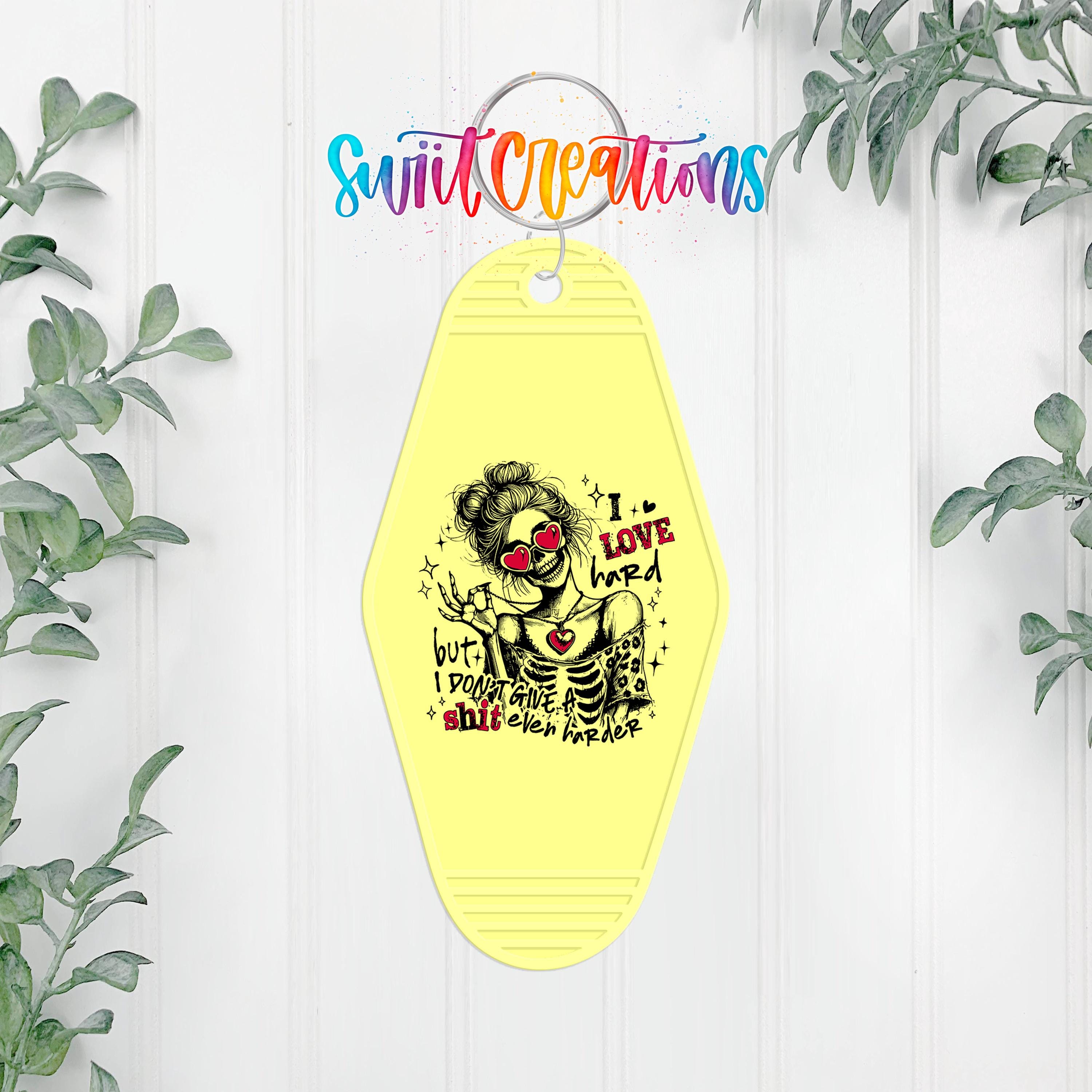 A yellow keychain with a black and white illustration of a skeleton wearing sunglasses and the text "I LOVE my hard body" printed on it.