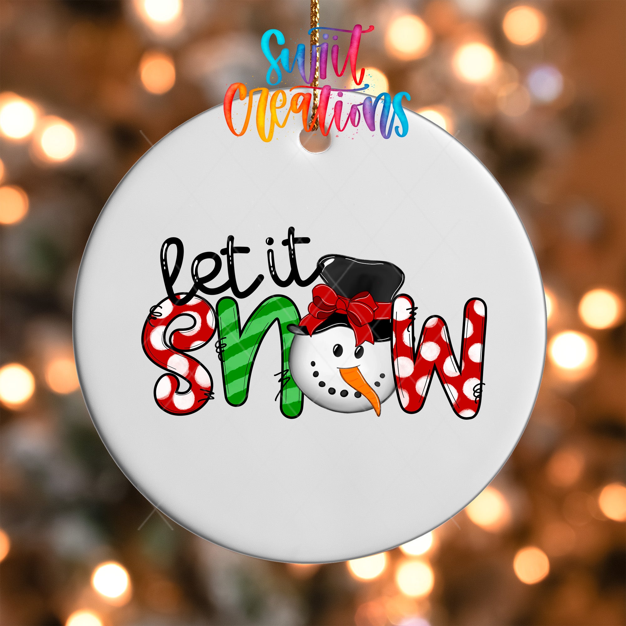 A white ornament with the text "let it snow" written on it, featuring a snowman design.