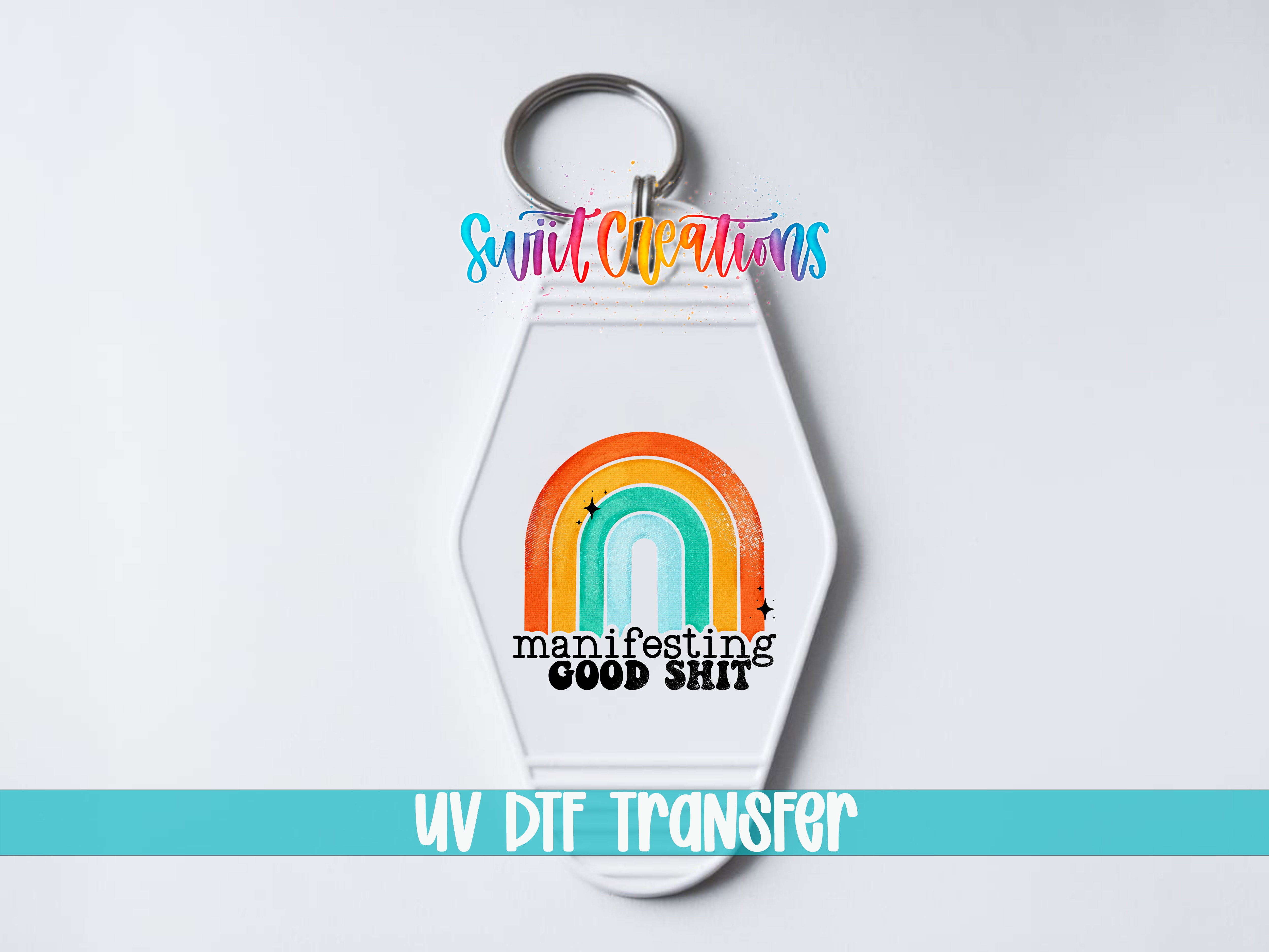 A keychain with a rainbow graphic and the text "manifesting good shit" printed on it.