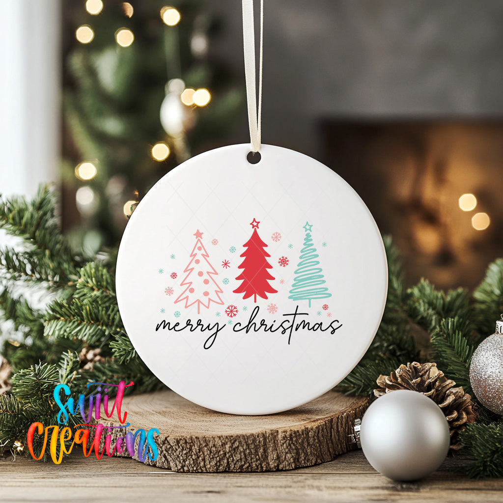 A white ceramic ornament with a festive design hangs on a wooden surface, surrounded by Christmas decorations such as pine cones and ornaments.