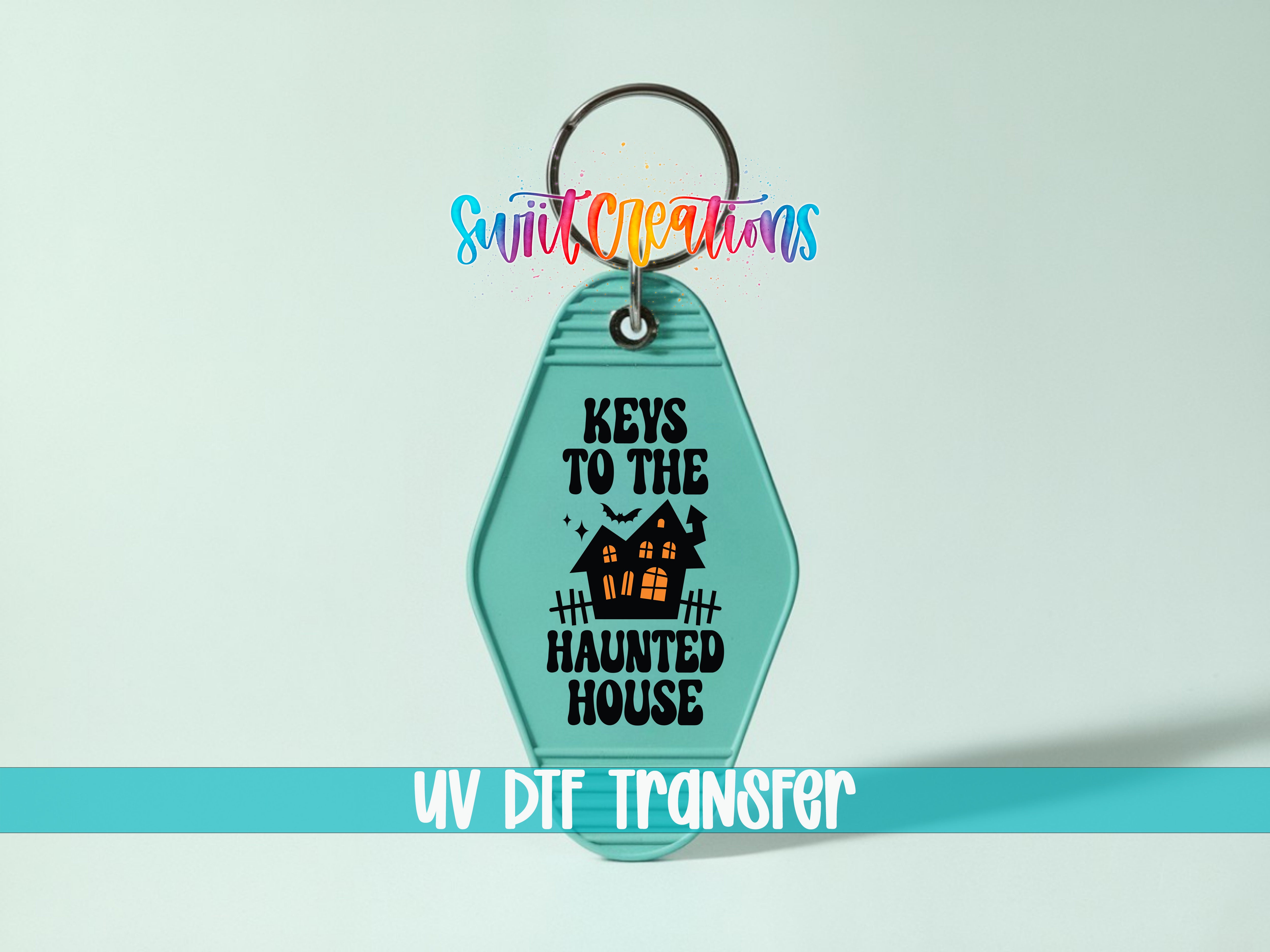 A keychain with the text "KEYS TO THE HAUNTED HOUSE" printed on it, along with a house illustration. The keychain is set against a light blue background, and there is a rainbow-colored text logo above it.