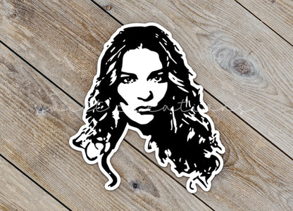 Close-up of the Alexis Portrait sticker on rustic wood