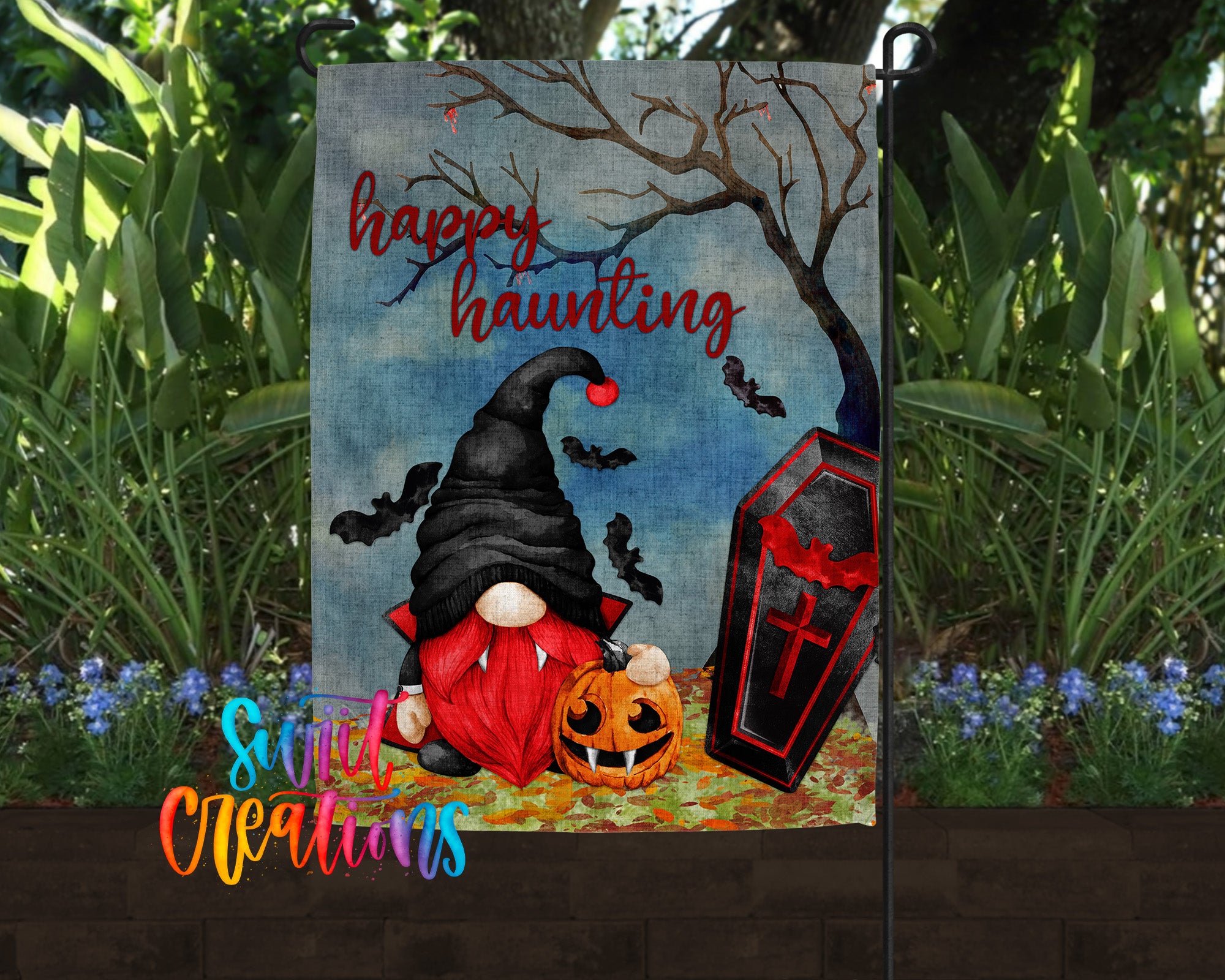 A Halloween-themed garden flag featuring a gnome, a carved pumpkin, and a casket with bats flying around it.