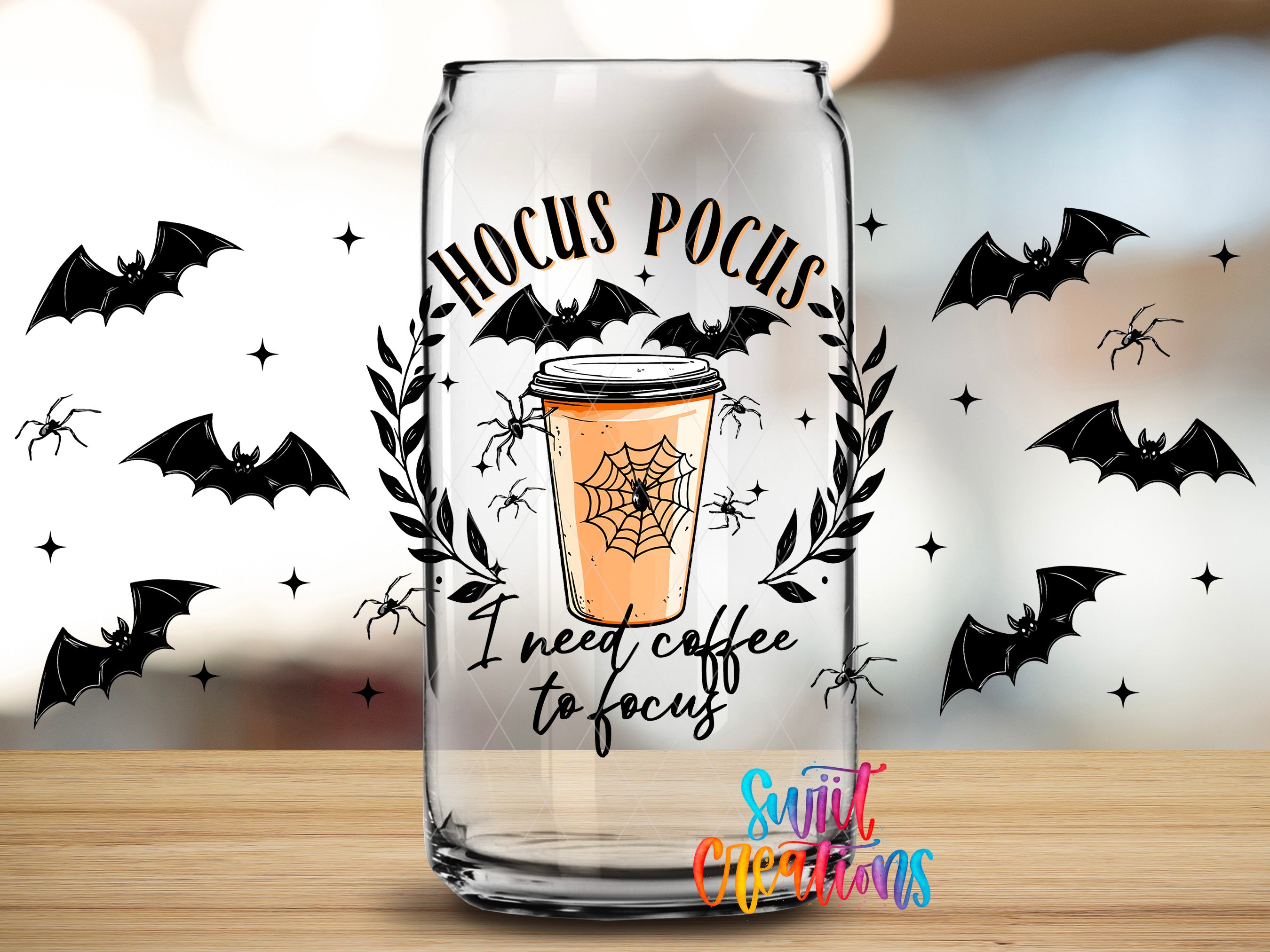 a glass can with a Halloween-themed design, including bats, a spider web, and a coffee cup.