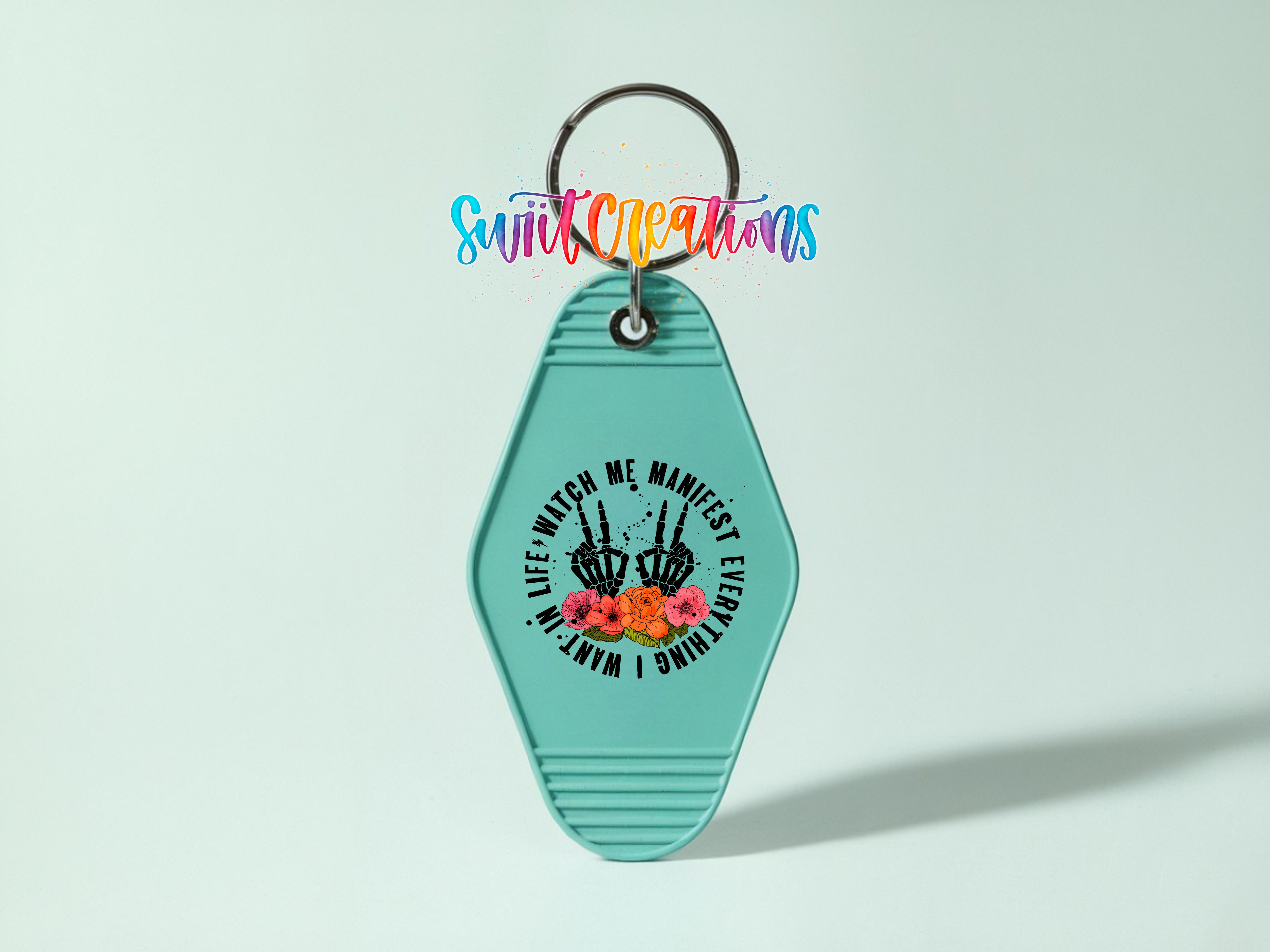 A turquoise keychain with a graphic design and text on it.