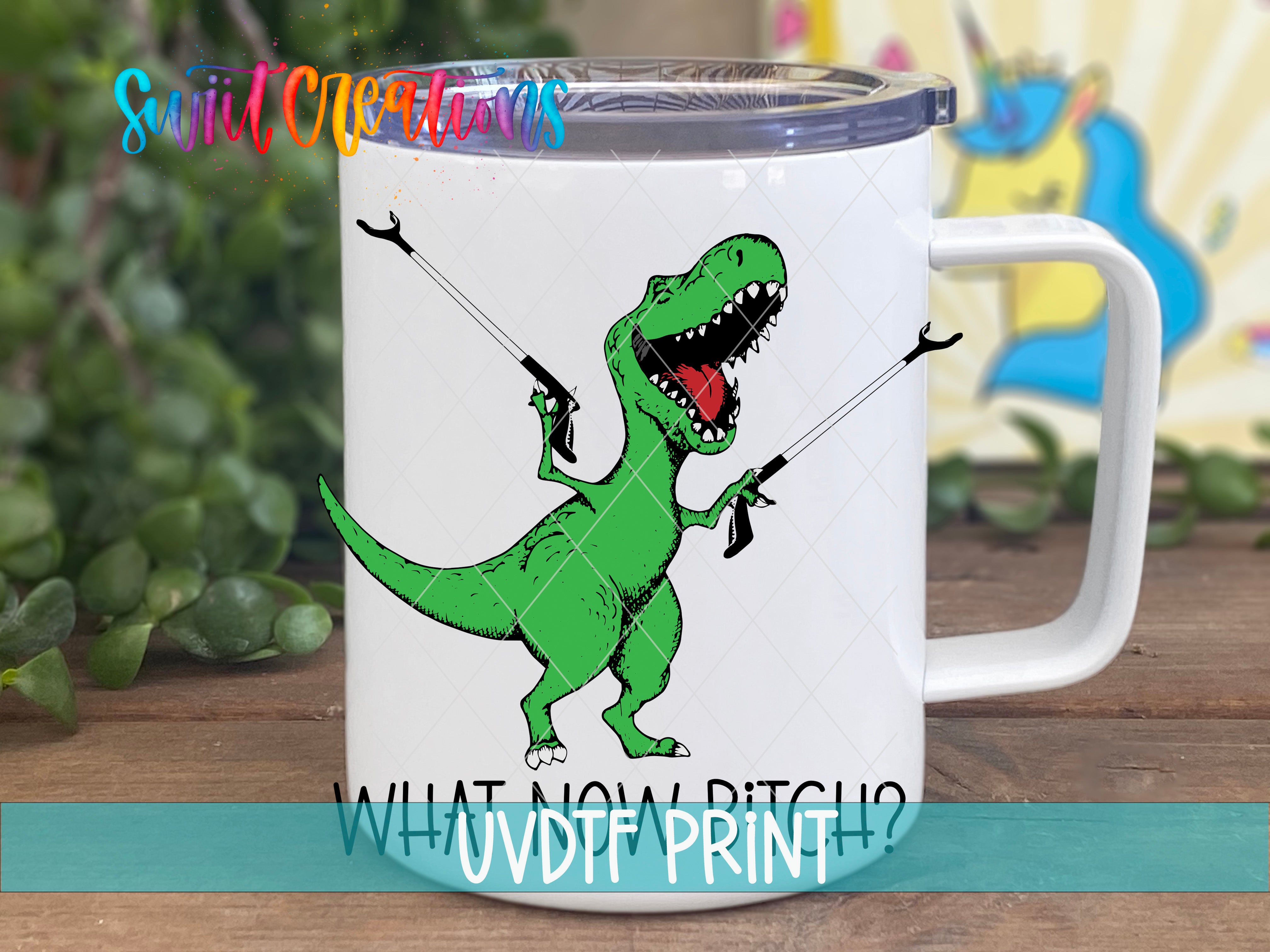 A white mug with a green dinosaur graphic and the text "WHAT NOW PITCH?" printed on it.