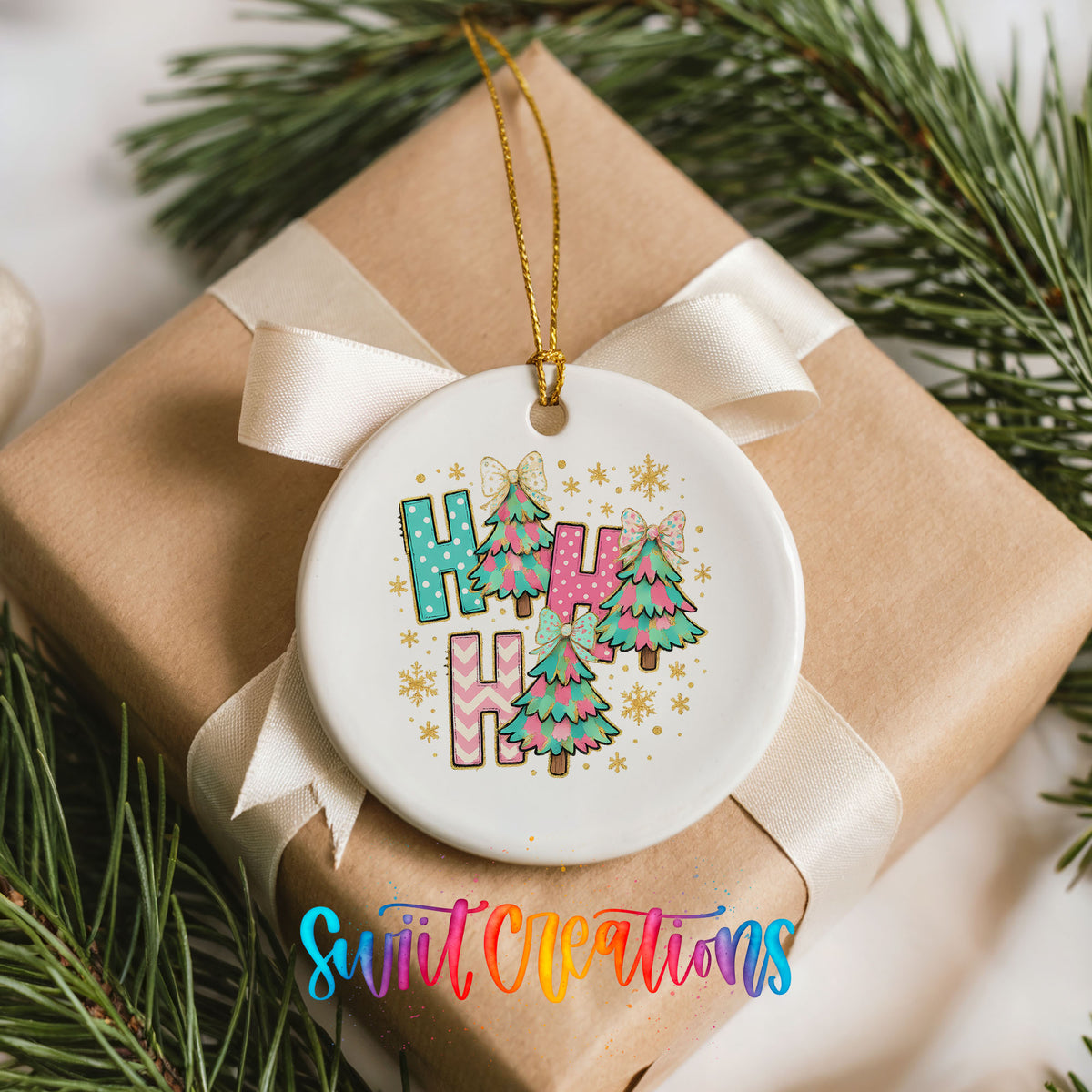 A white ceramic ornament with a ribbon and pine branches, featuring a colorful design with the text "HAPPY" and Christmas trees.