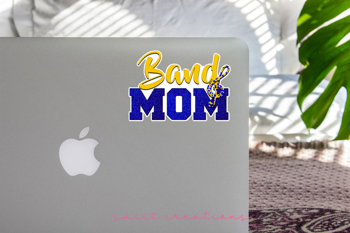 Gold and Blue Band Mom sticker on the lid of a silver laptop